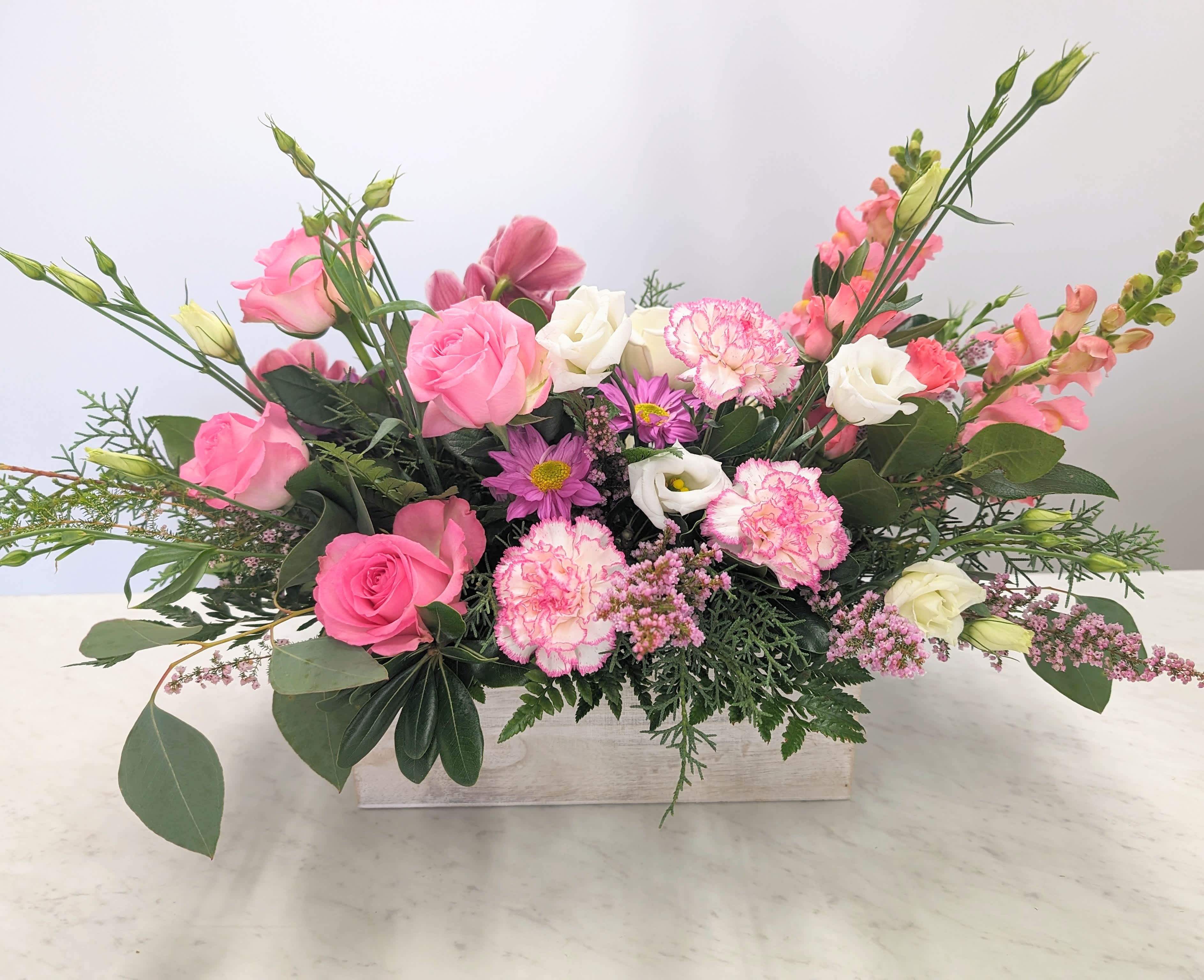 Pink and white mixed flower arrangement in a rectangular wooden box