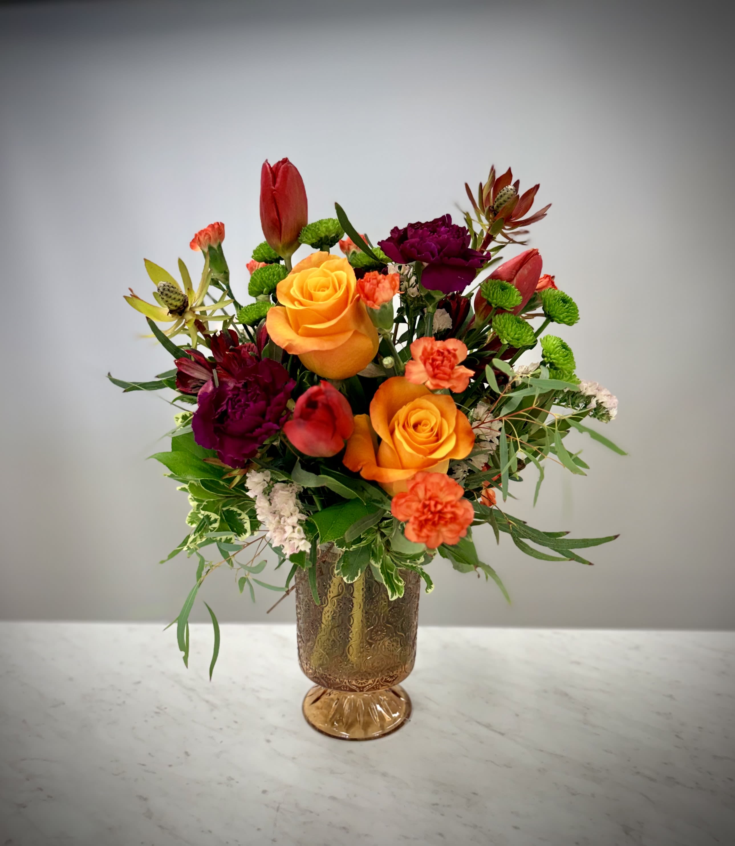 Vintage Forever - Groovy baby!! On "That 70's Show" Kitty Forman was a hardworking nurse, a kind and loving spouse, and a devoted mother to Eric and Lori (and all of their friends). Her unique charm and wit remind us of our own moms and all the love and support they've given us over the years. This 70's inspired arrangement was created for the grooviest of moms! Remind her what a cool cat she is this Mother's Day.  Eric: Oh, Mom. Oh, my god, Mom. I had her in my sights. I mean, she was right in the cross hairs. Kitty: Oh, honey... You know I love you and your sister equally. But if you ever get an opportunity again, for God's sake, pull the trigger.