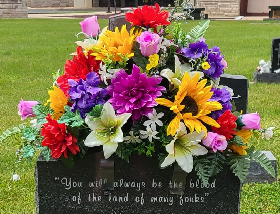 Colorful floral arrangement on a gravestone in a cemetery