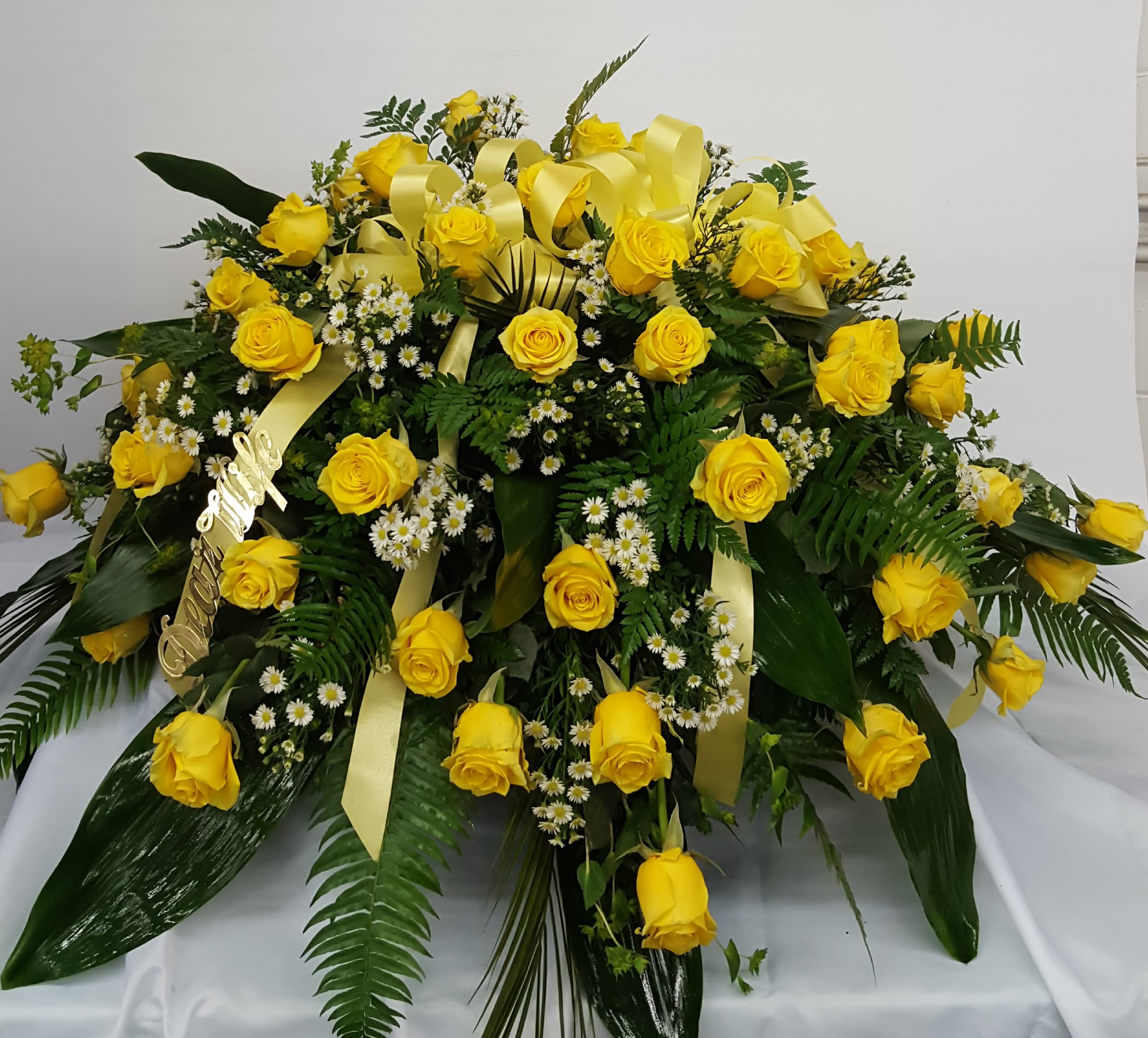 Large yellow rose arrangement with white filler flowers and ribbon accents