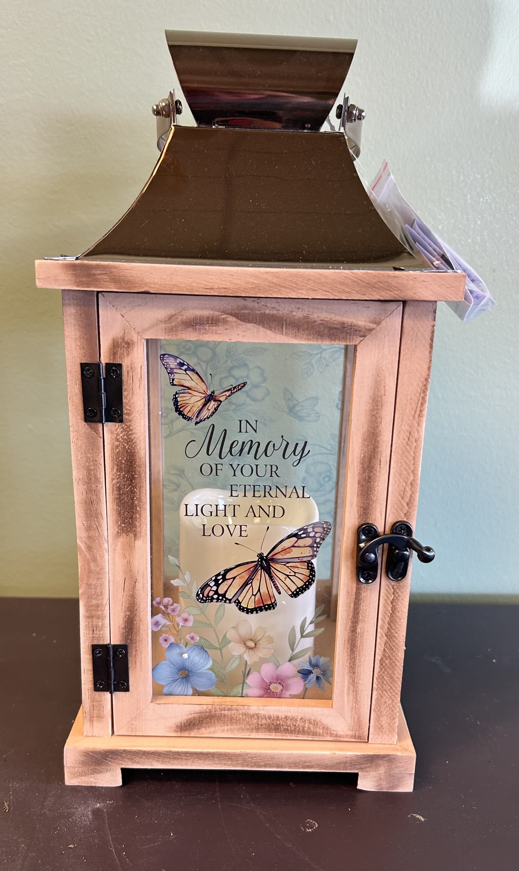 Wooden memorial lantern with butterfly artwork and a candle inside