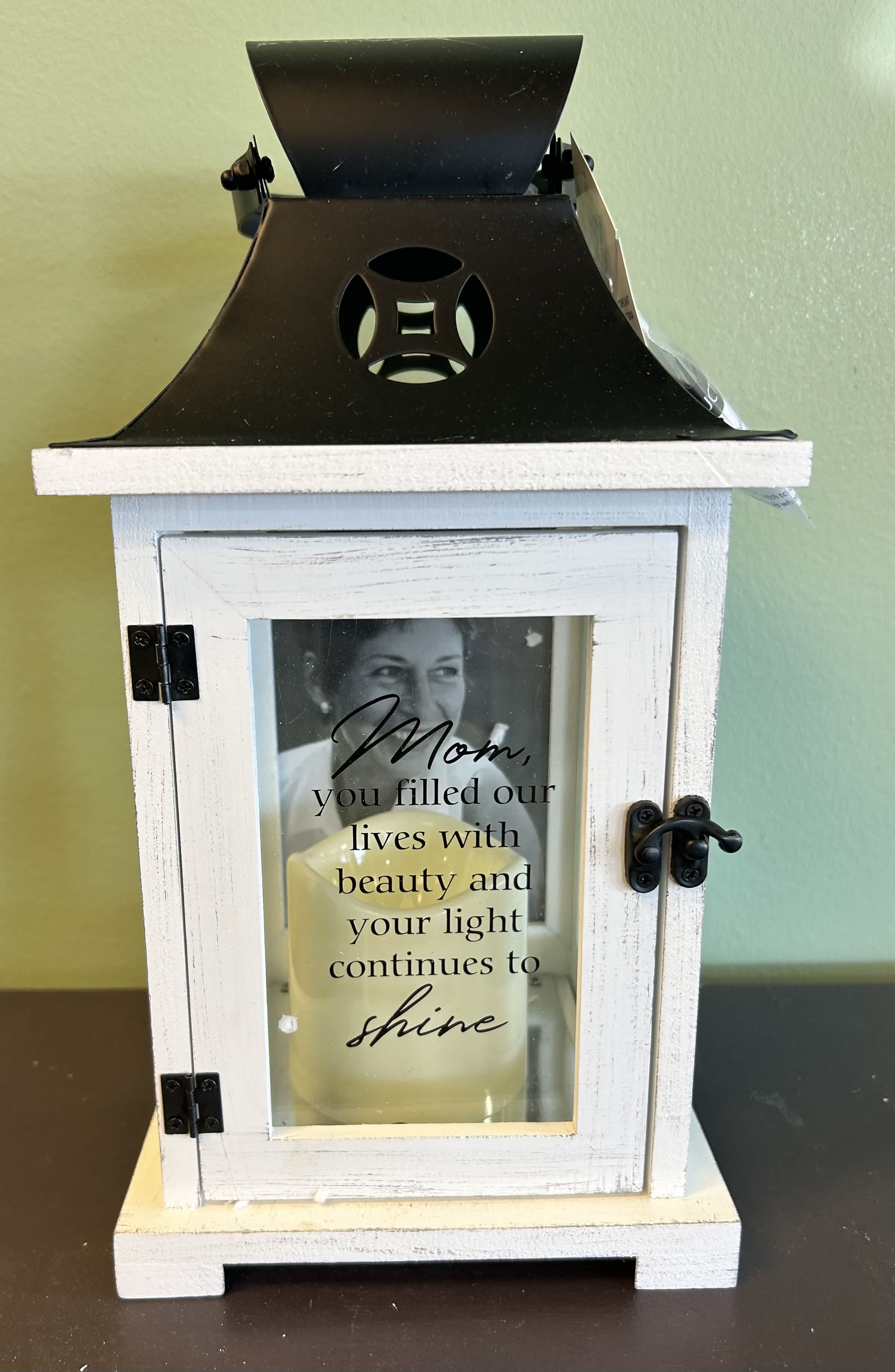 White wooden memorial lantern with a candle and tribute message