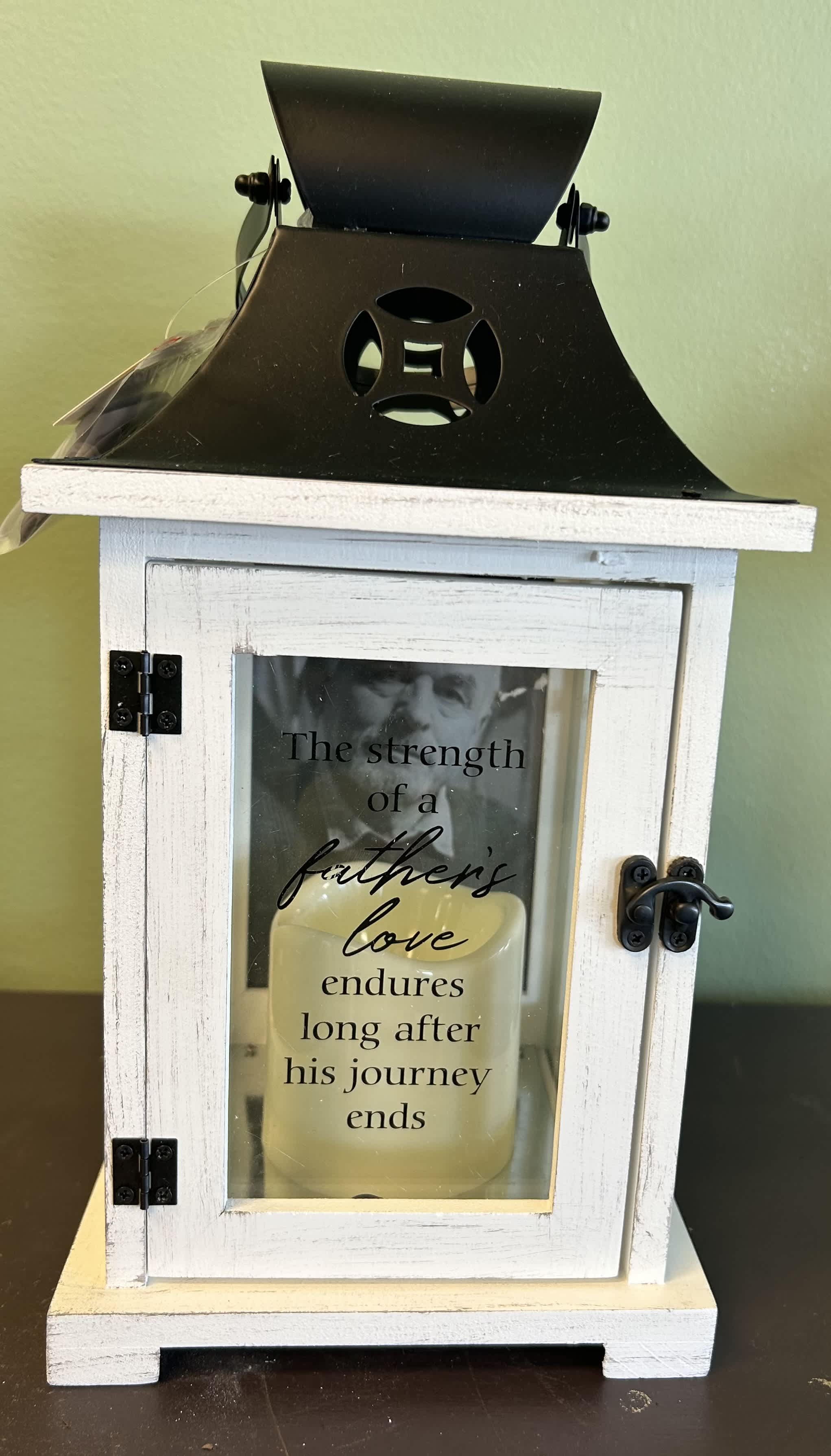 White memorial lantern with a candle and father’s love message