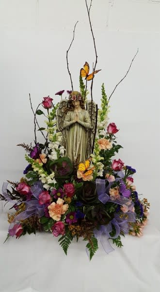 Floral arrangement with an angel figurine, roses, and butterflies