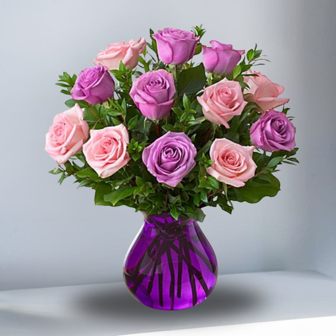 Rose Romance - When it comes to being romantic, you can never go wrong with roses! One dozen fresh, gorgeous blooms in a mix of pink and purple are hand-gathered by our expert florists in a purple glass vase to help you express all the love that's in your heart. One dozen of our freshest pink and purple roses, arranged with salal and myrtle Hand-gathered by our florists in a purple glass vase.