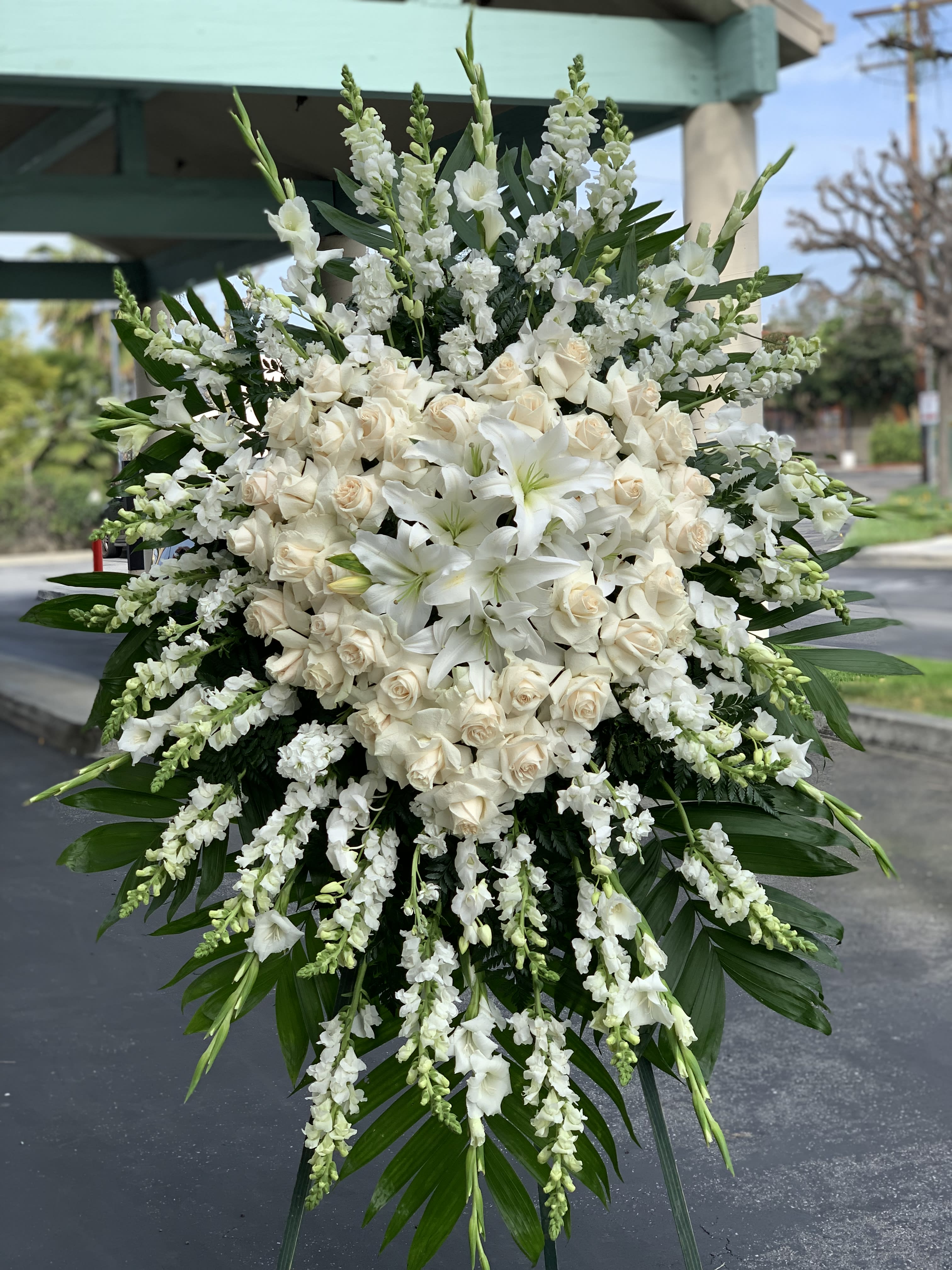 Large white funeral spray with roses and lilies