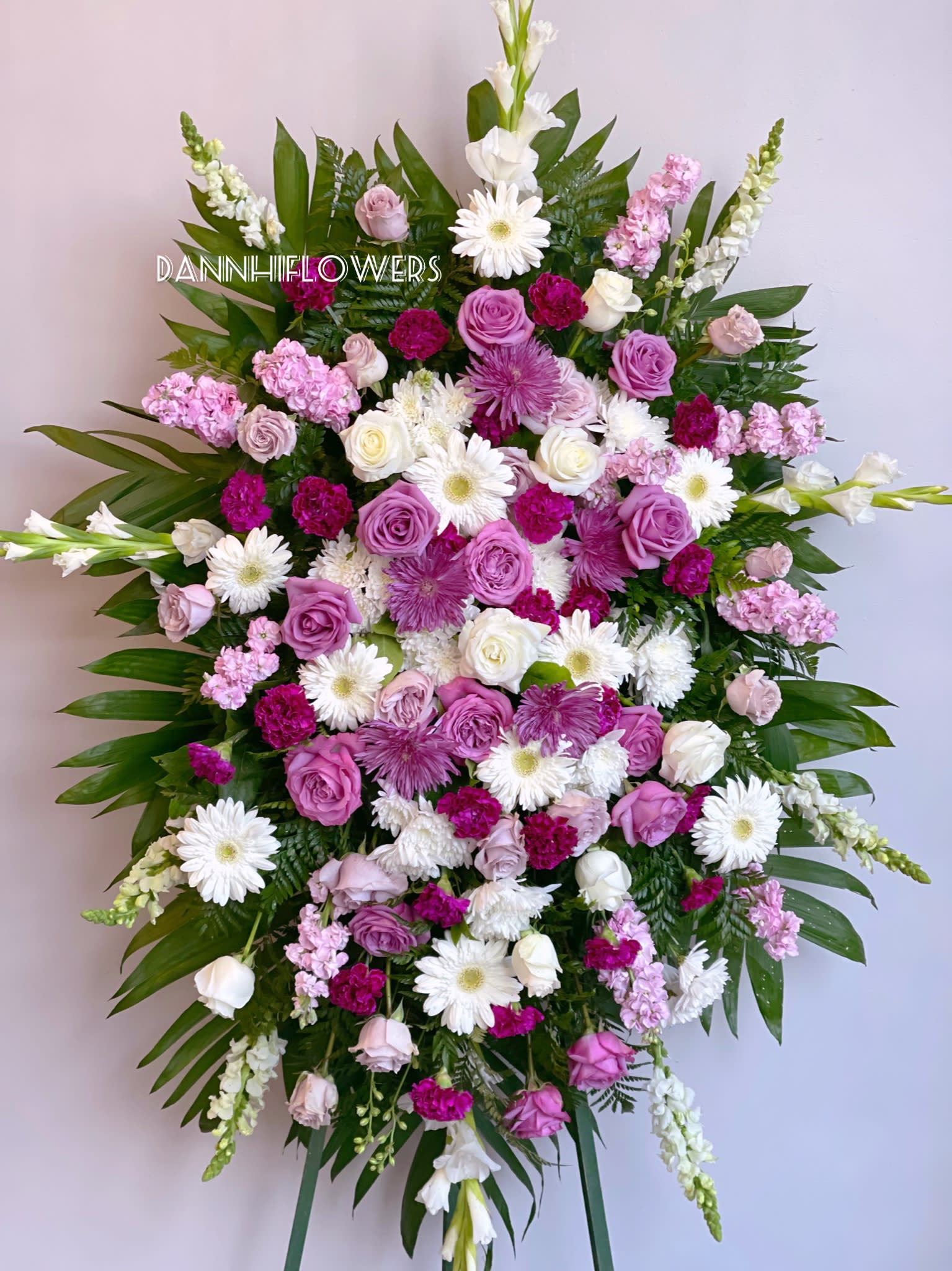 Large standing spray of pink, white, and purple flowers on an easel