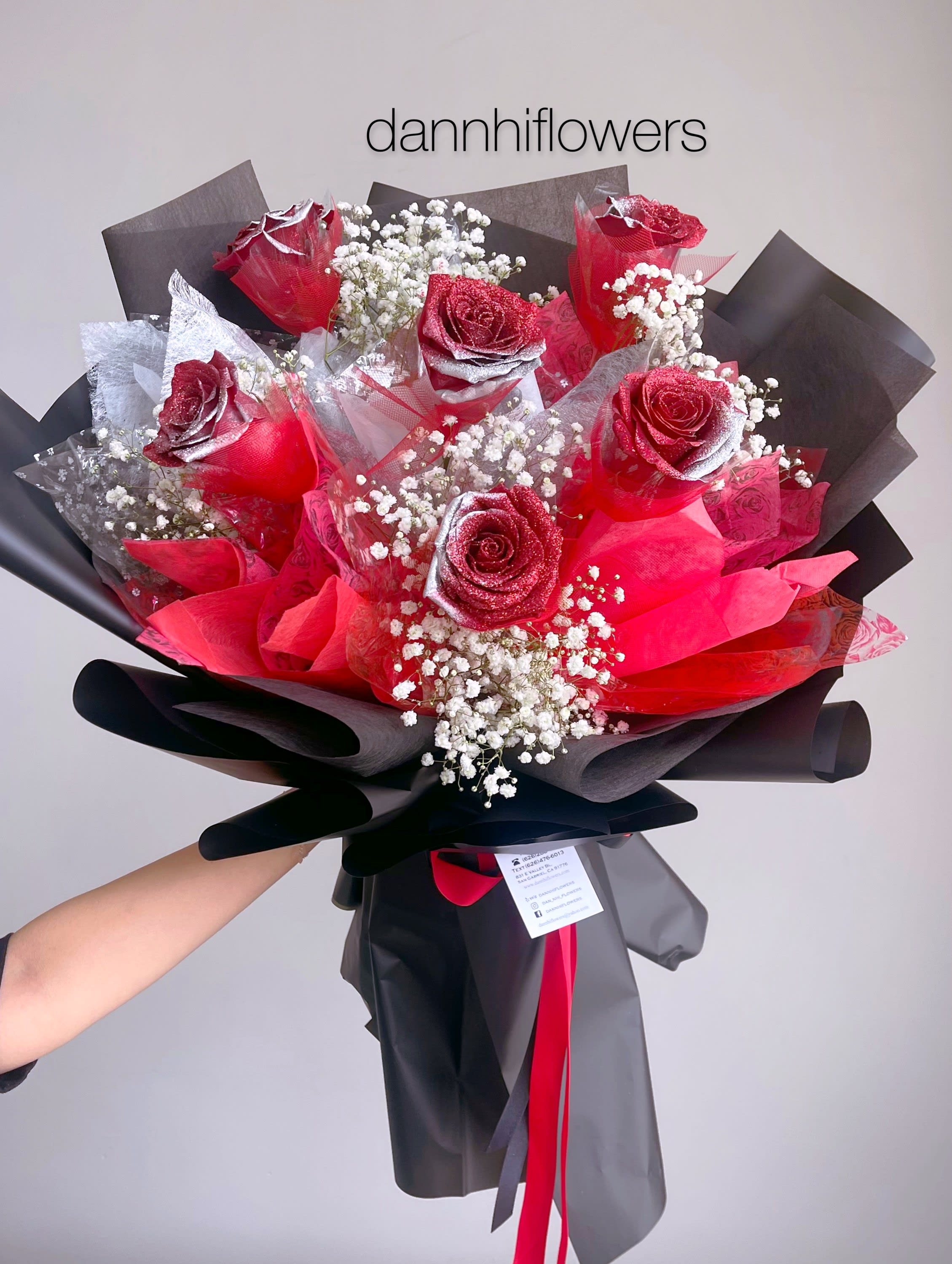 Bouquet of red roses with baby's breath wrapped in black paper