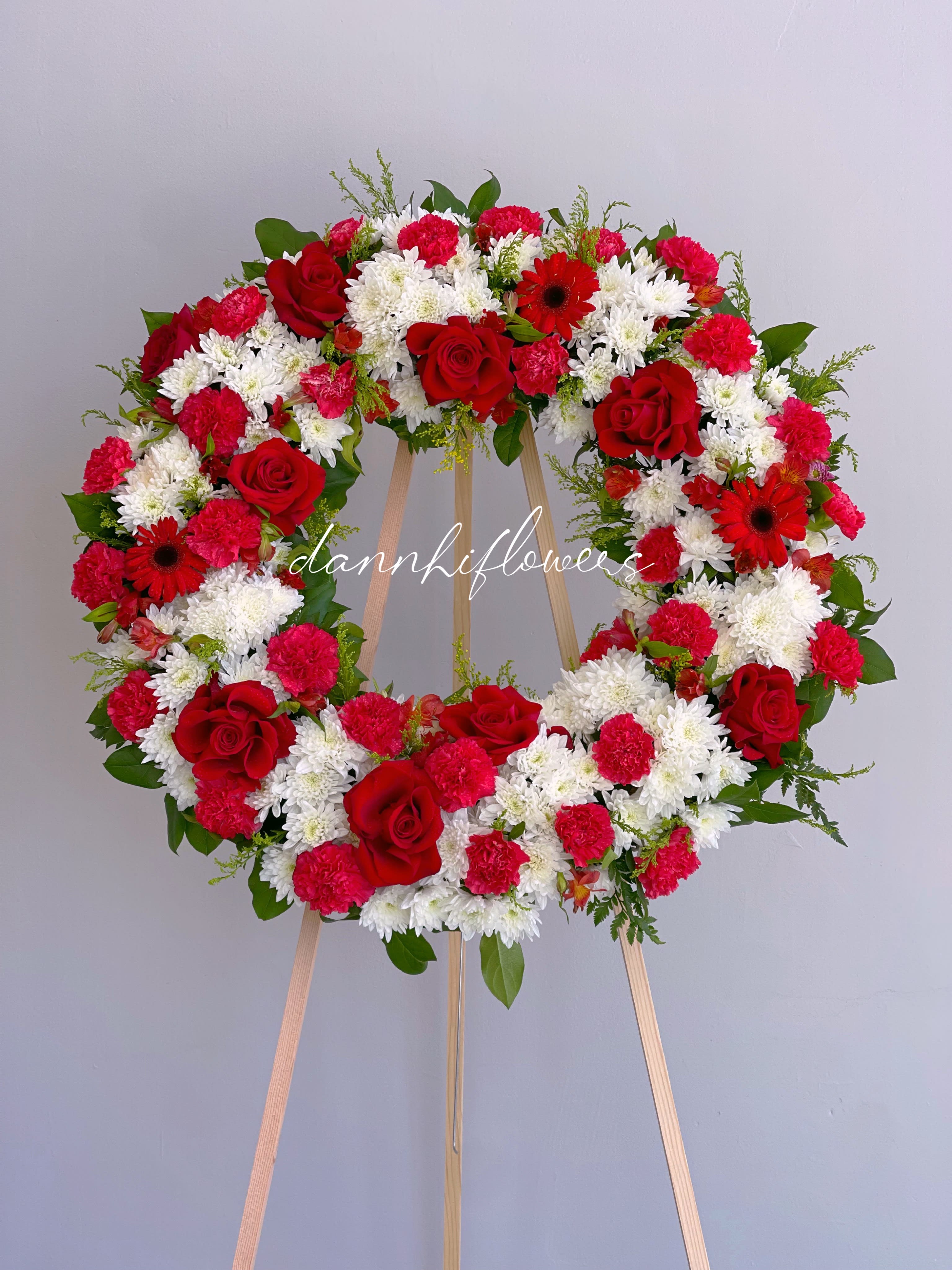 Red and white floral wreath on a wooden easel
