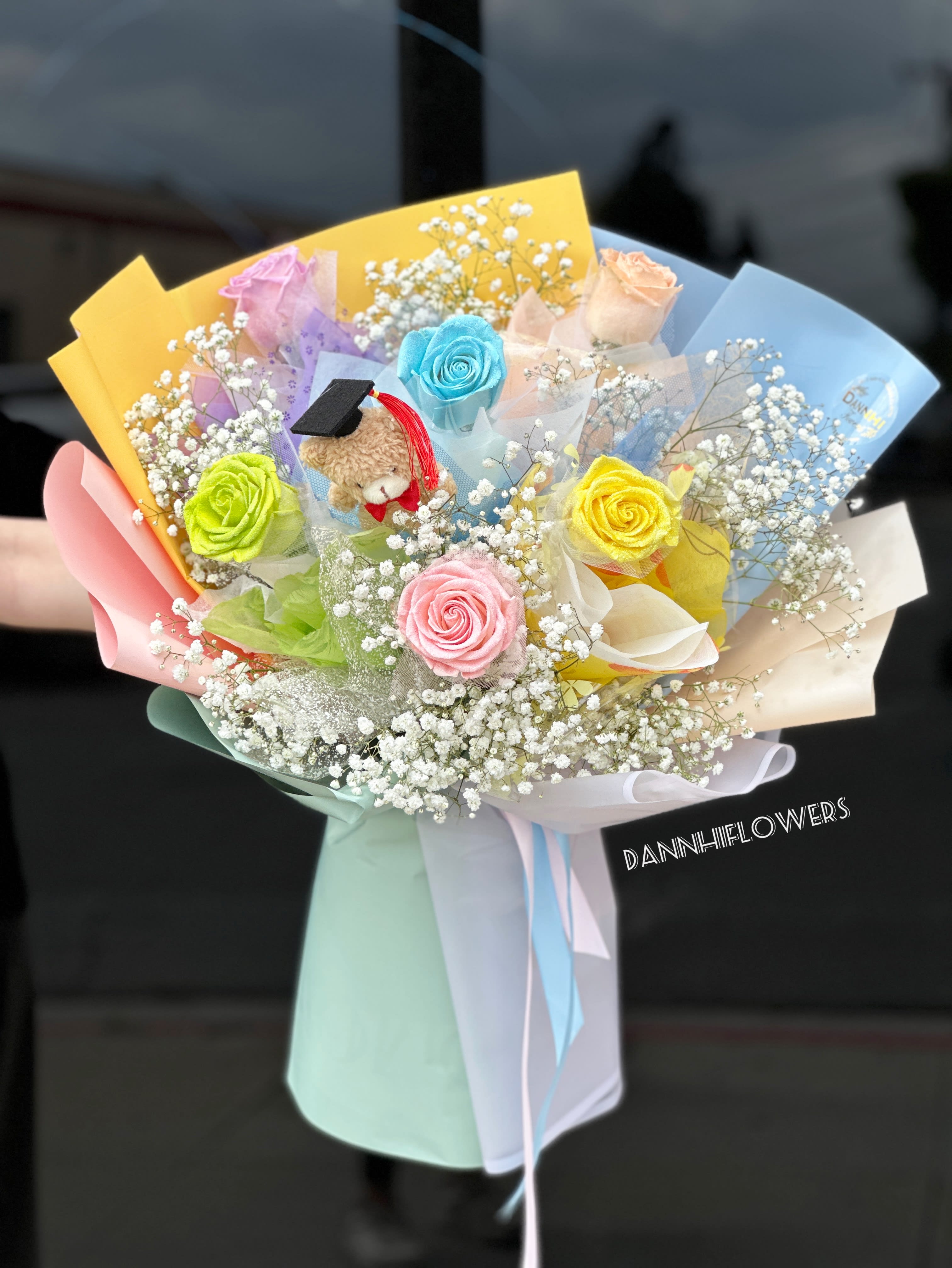 Colorful bouquet with roses, baby’s breath, and a small teddy bear