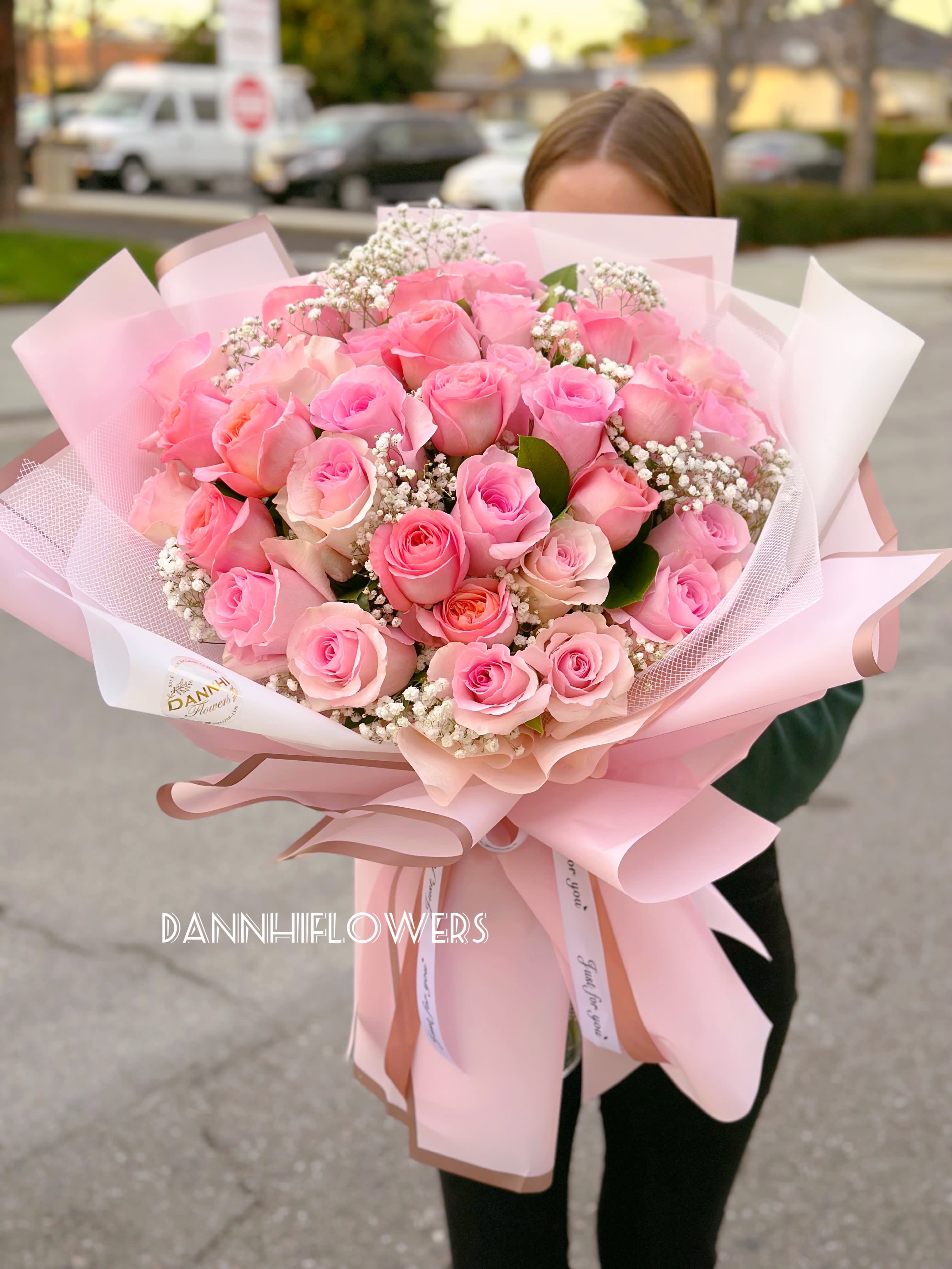 Large bouquet of pink roses wrapped in pale pink paper