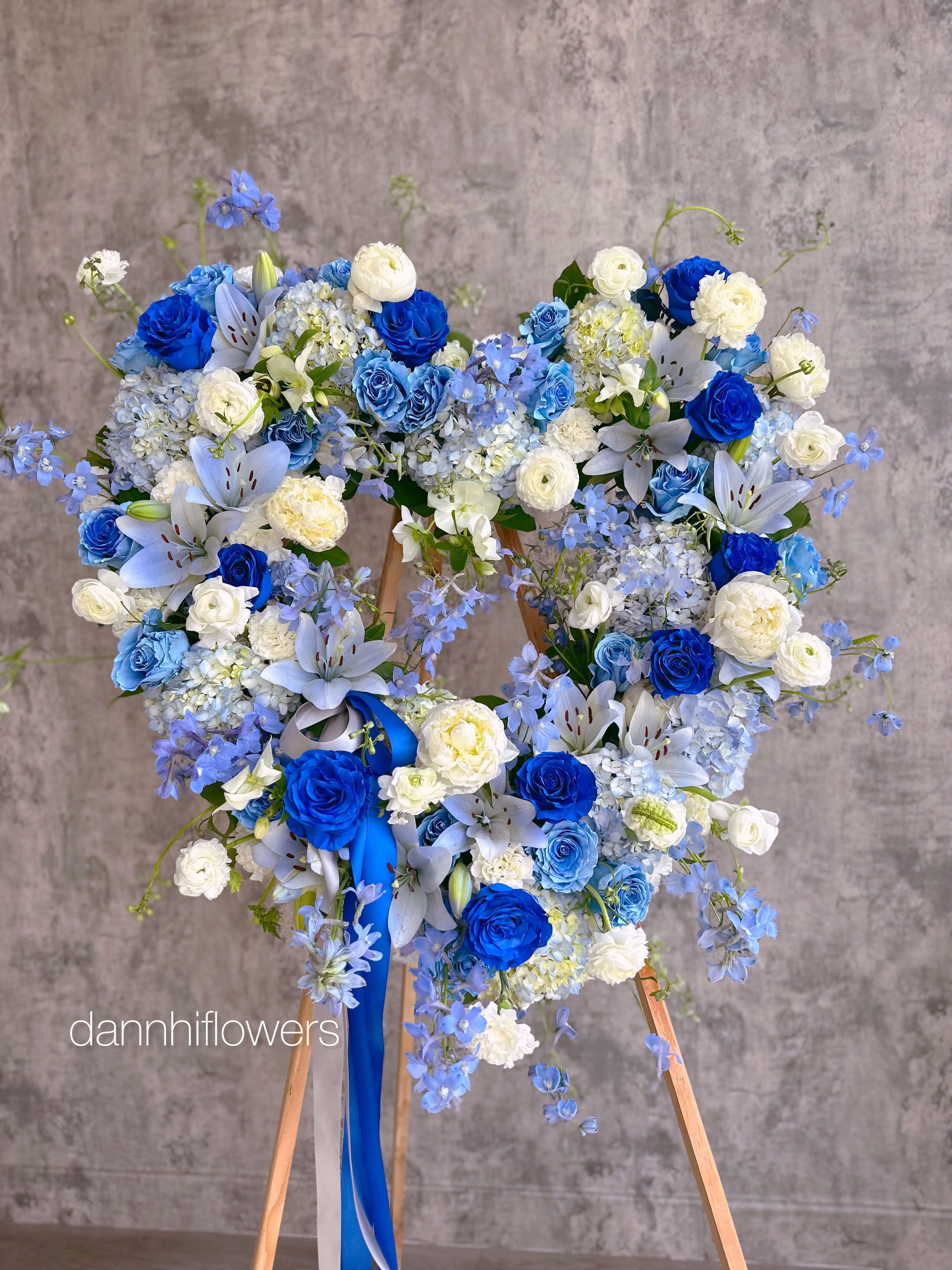 Blue and white floral wreath on a wooden stand