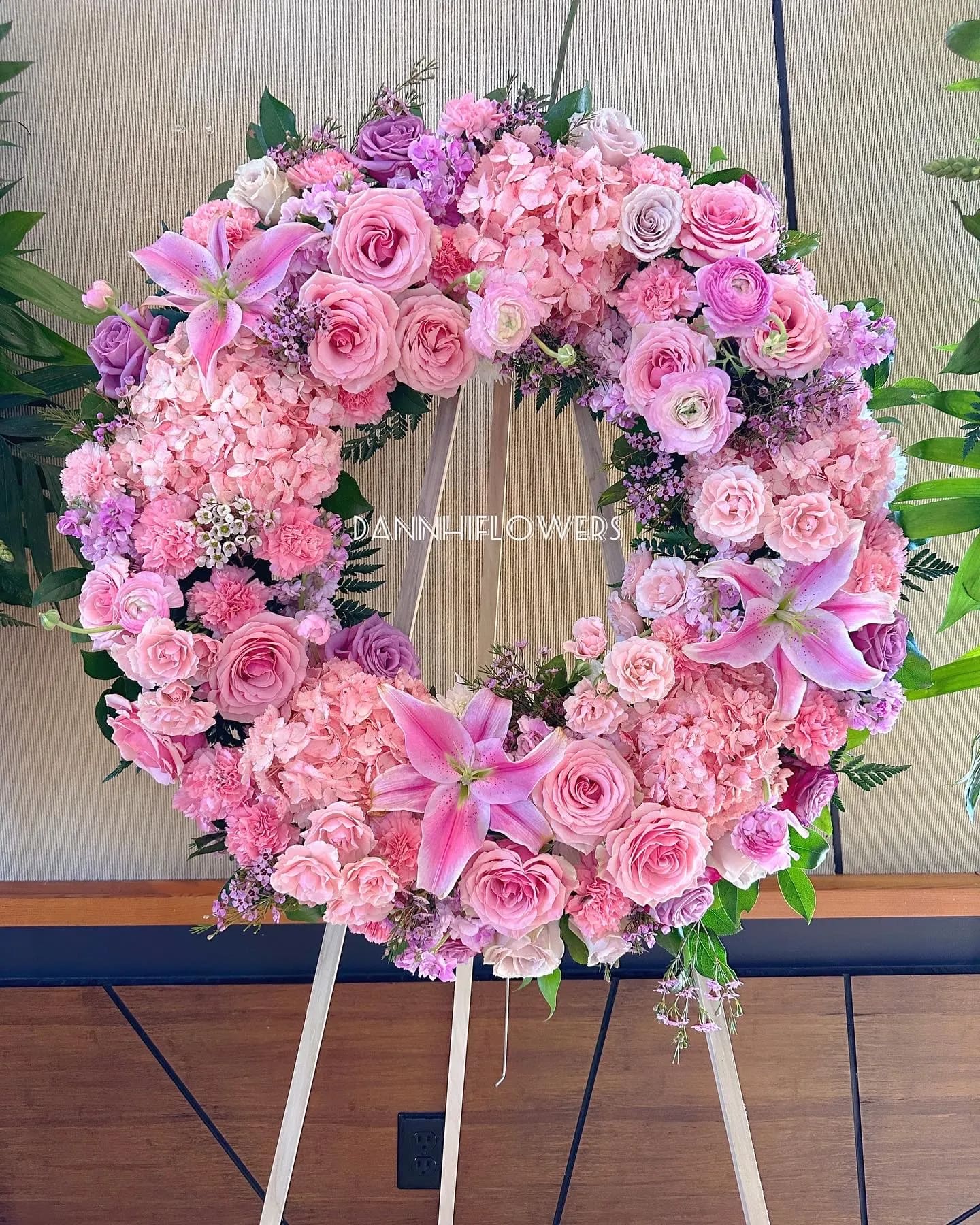 Pink and lavender floral wreath on a wooden easel