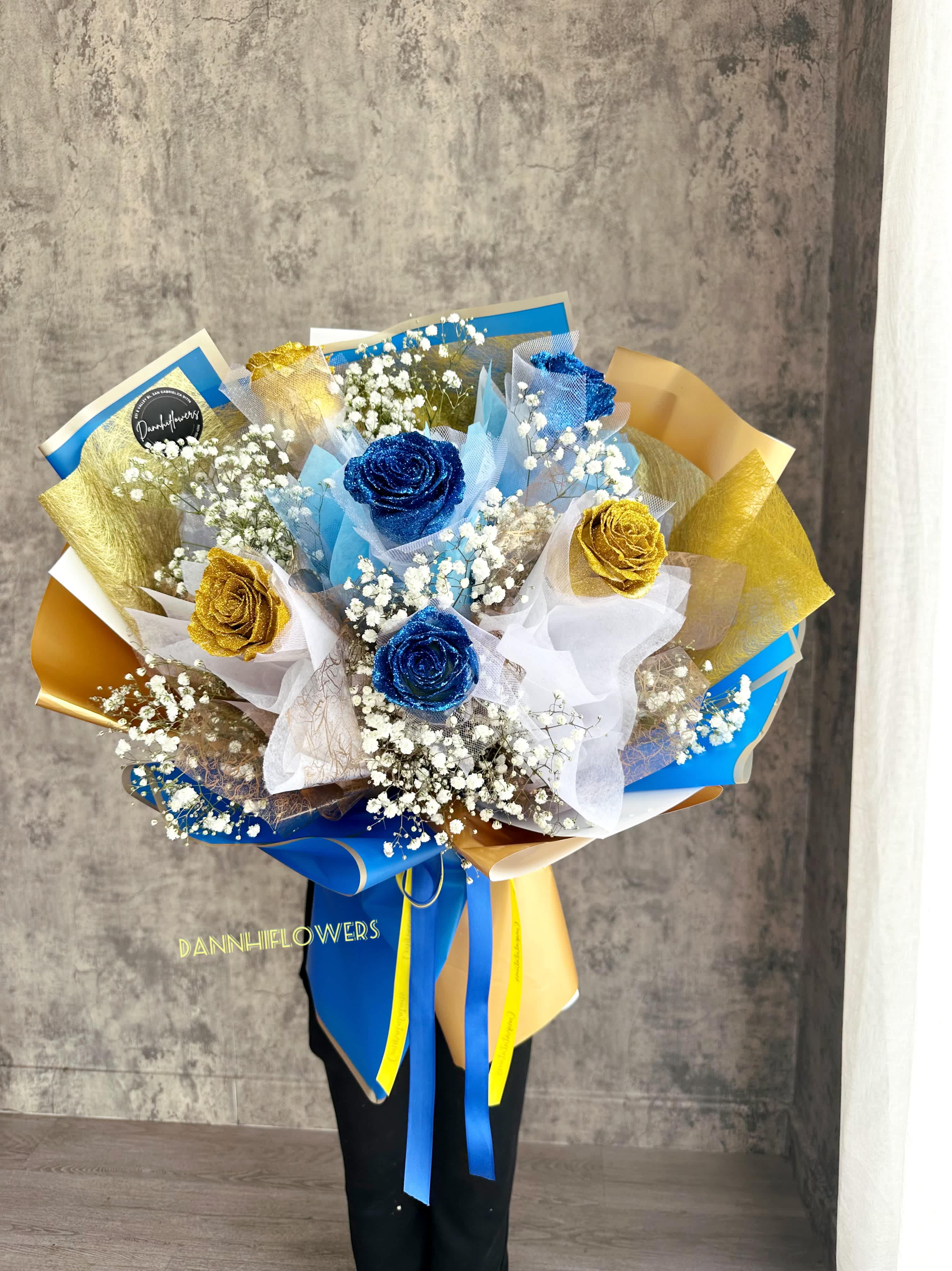 Bouquet of blue and gold roses with white baby's breath