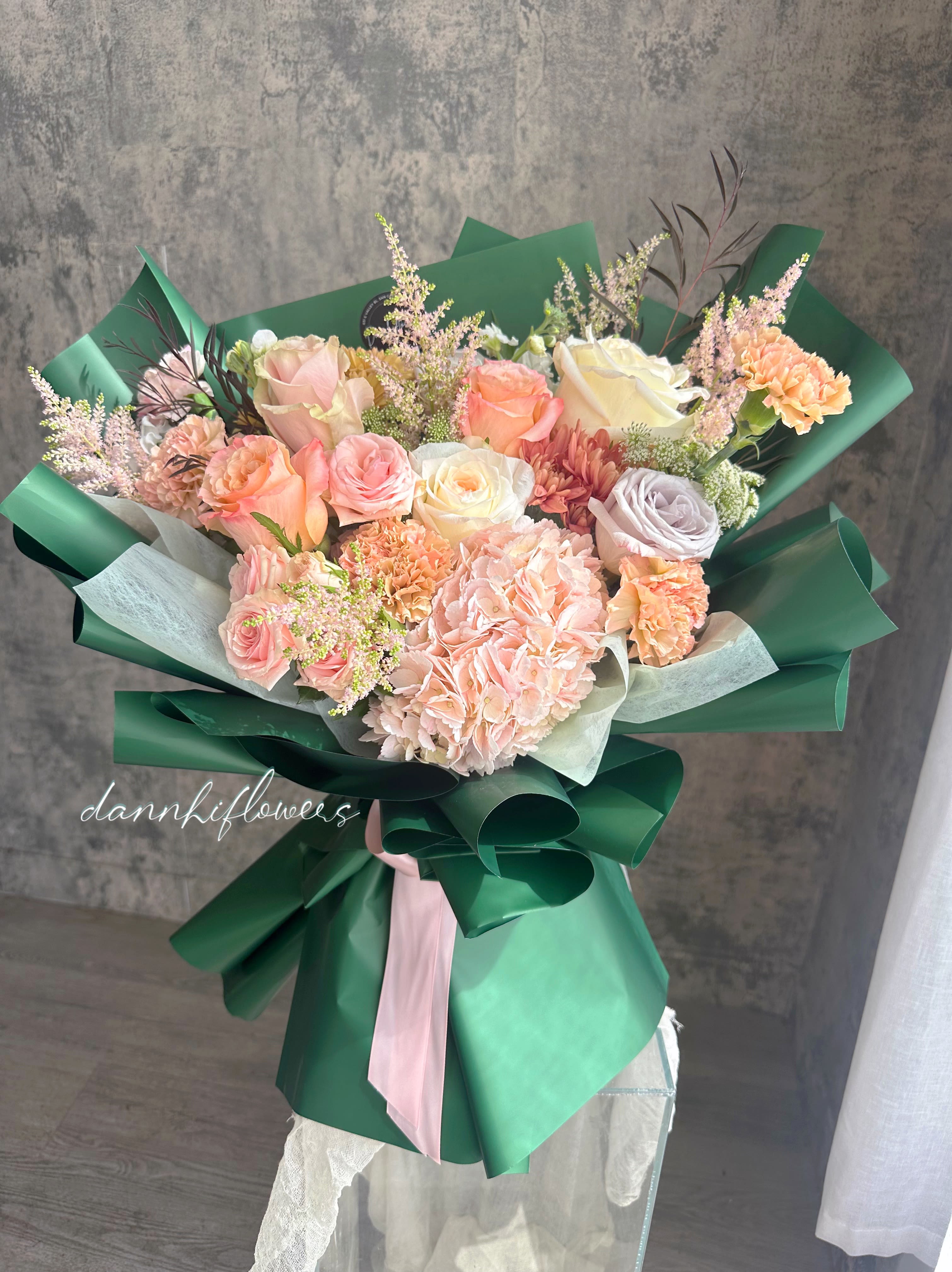 Emerald charm - The bouquet features  a soft, romantic color palette, wrapped in rich emerald paper delivering a lush, luxurious, and sophisticated style, perfect for any special occasion or celebration.  * All of our bouquets are wrapped with water in cellophane to keep the flowers fresh. If you need a vase, you can add it during checkout. Please let us know in the instructions if you prefer the bouquet without water.  Care Instructions: Please DO NOT remove the paper wrapping. The cellophane with water underneath acts as the vase. The next day, you can cut away the cellophane and gently hold all the flower stems with both hands inside the design paper, then place them in a vase with water. If possible, please change the water daily.  