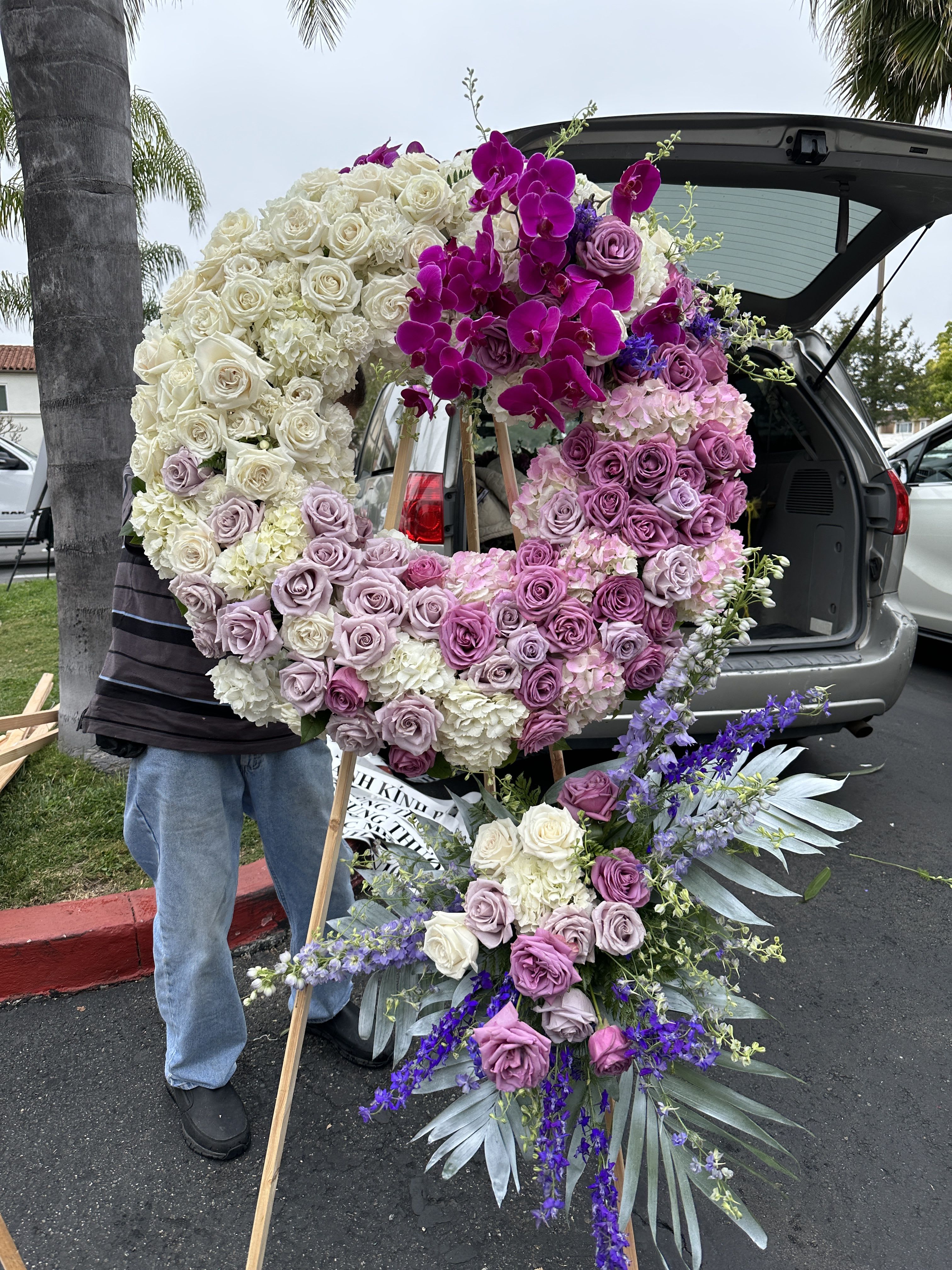 Large floral wreath with pink, purple, and white roses on an easel