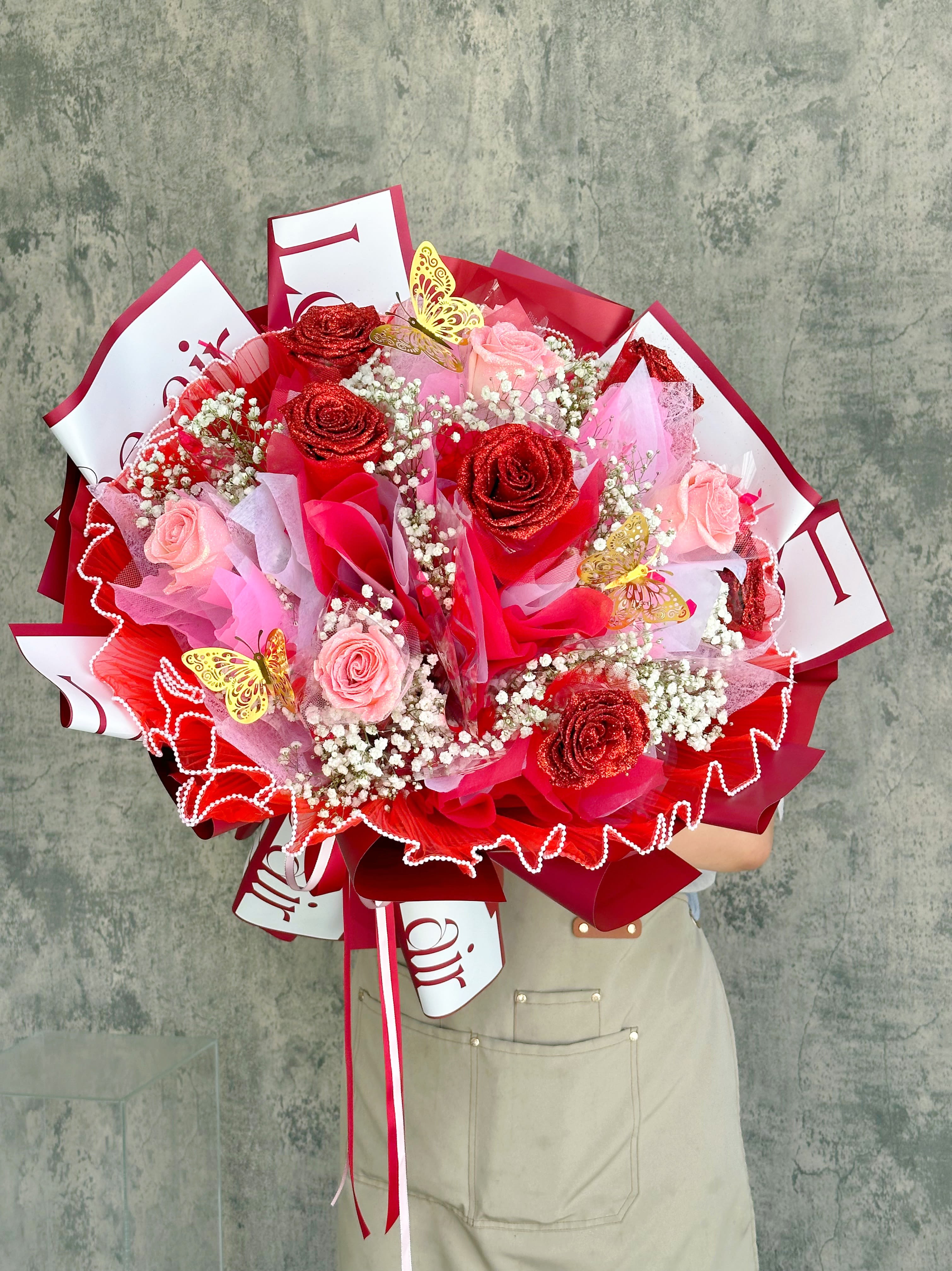 Large bouquet of pink and red roses with butterfly decorations