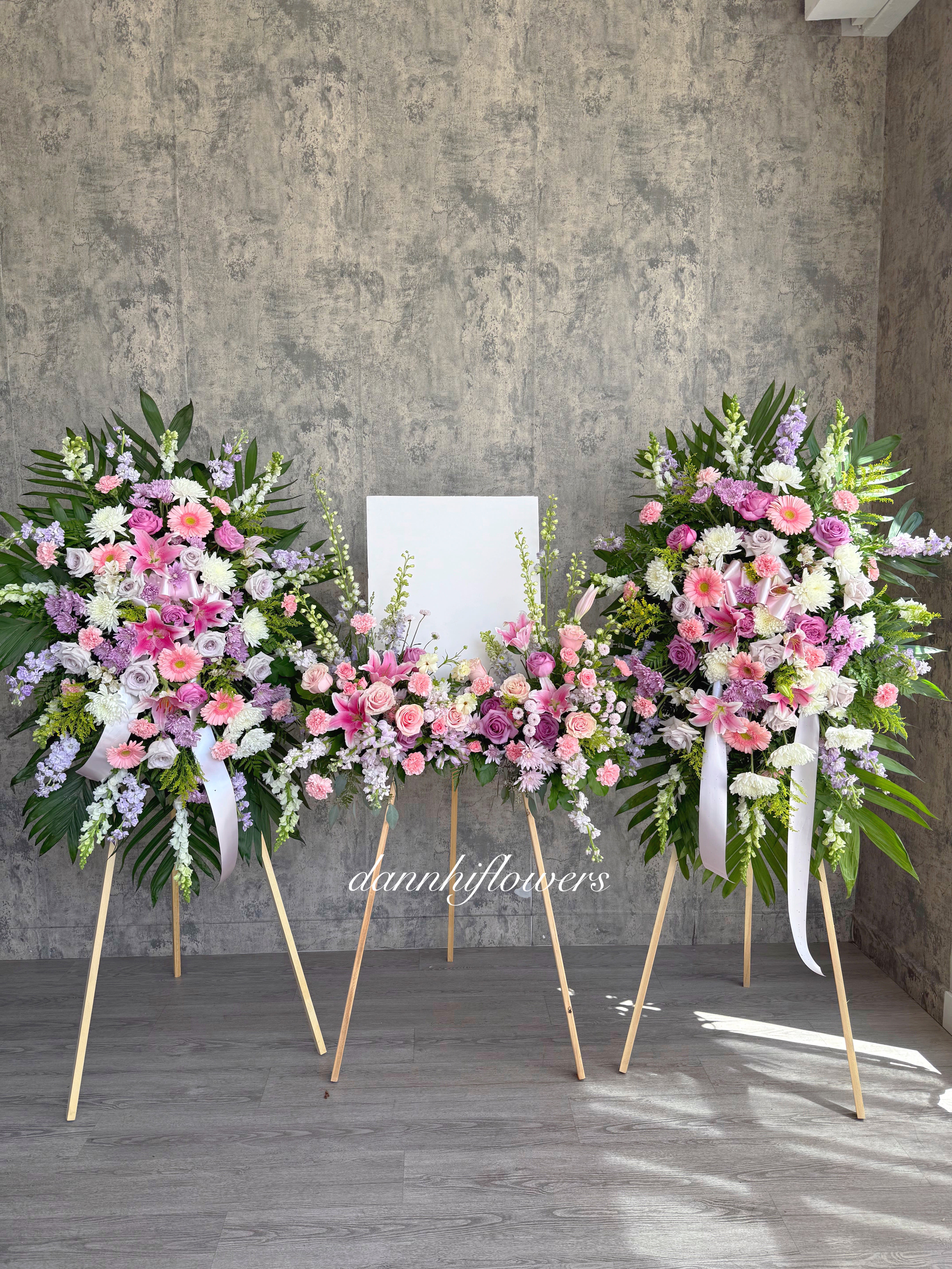 Three pastel floral standing sprays on easels with a blank center panel