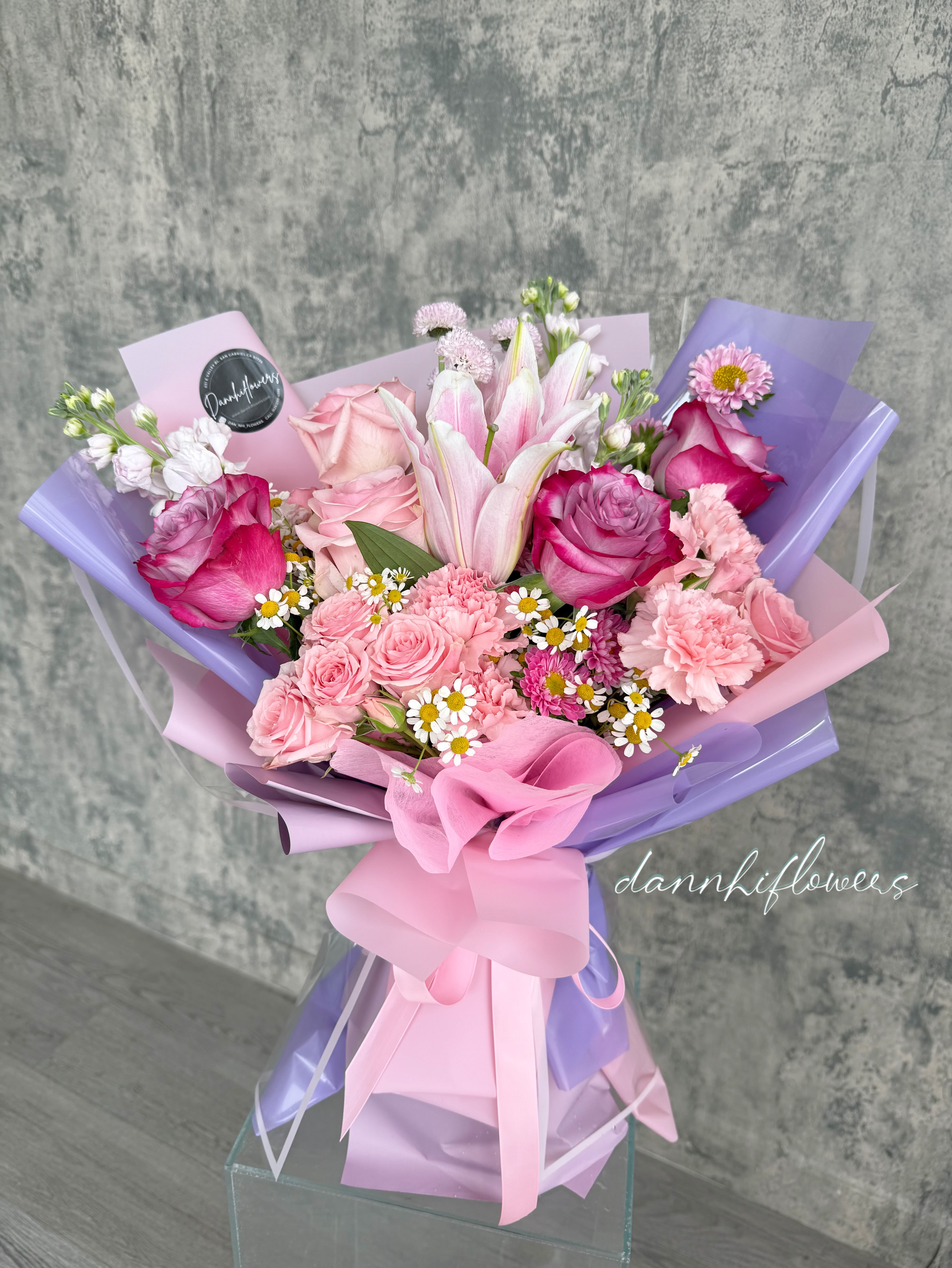 Pink and lavender bouquet with roses, lilies, and small daisies