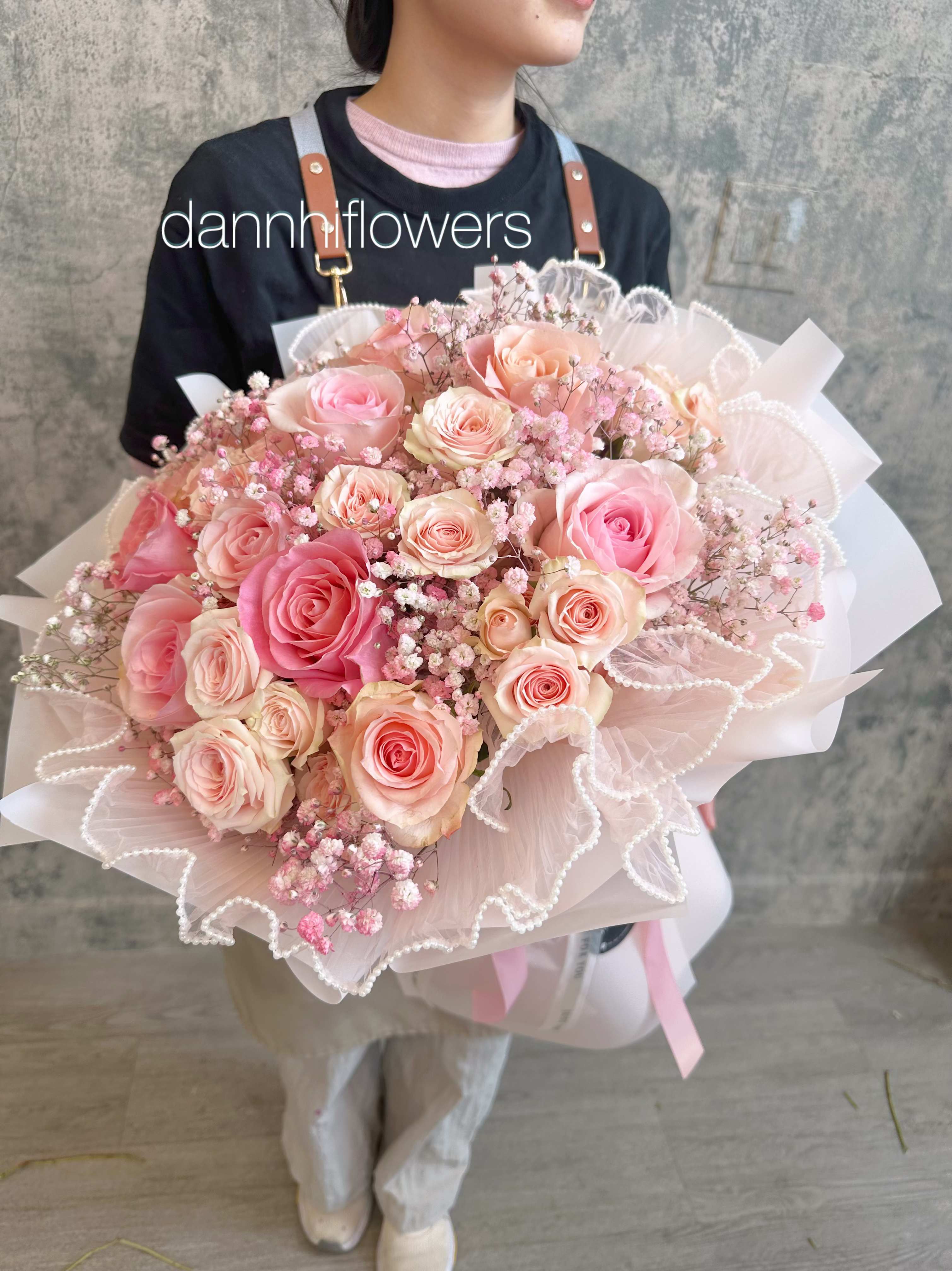 Large bouquet of pink and peach roses wrapped in pale pink paper