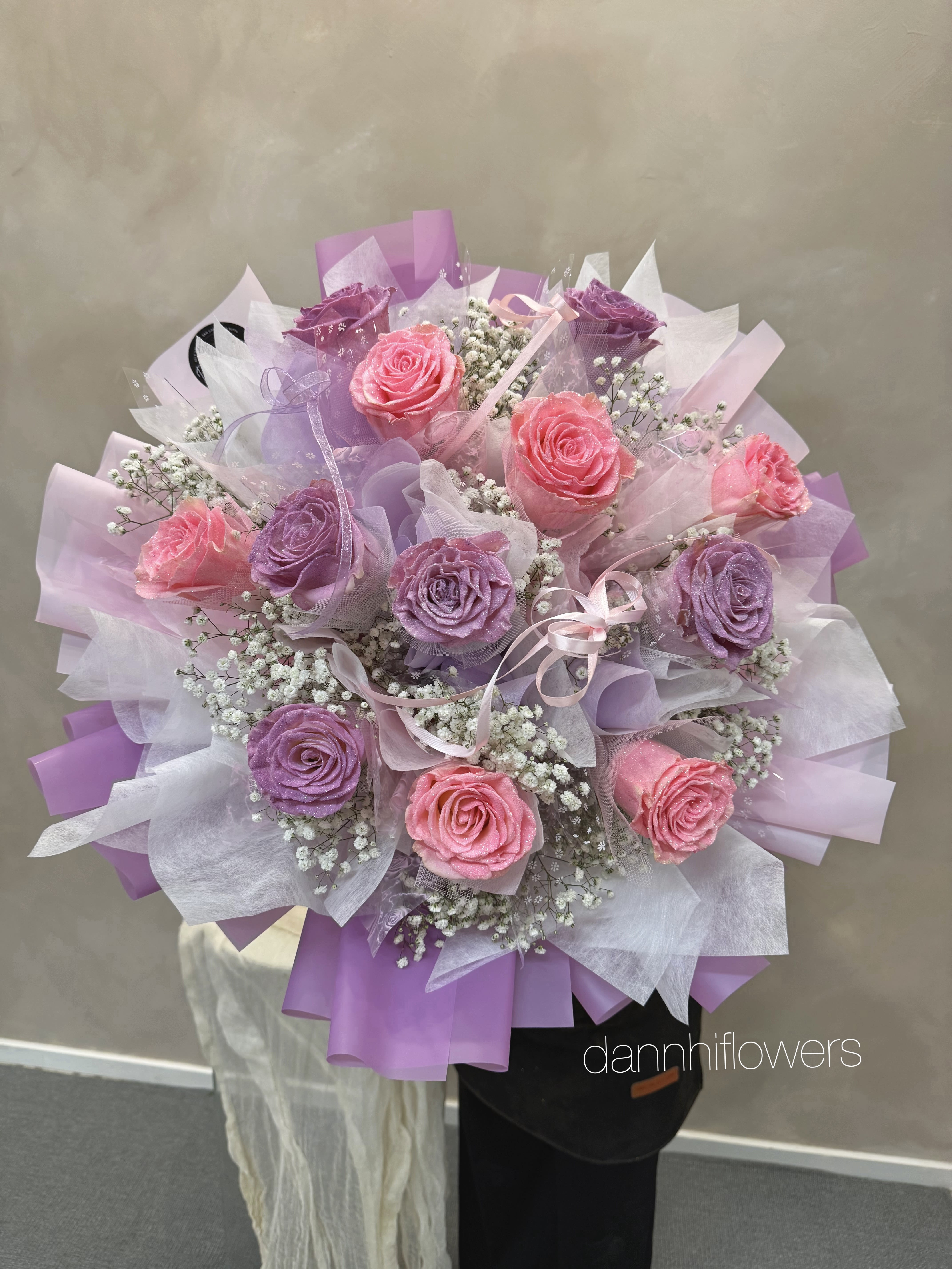 Bouquet of pink and purple roses wrapped in lavender paper