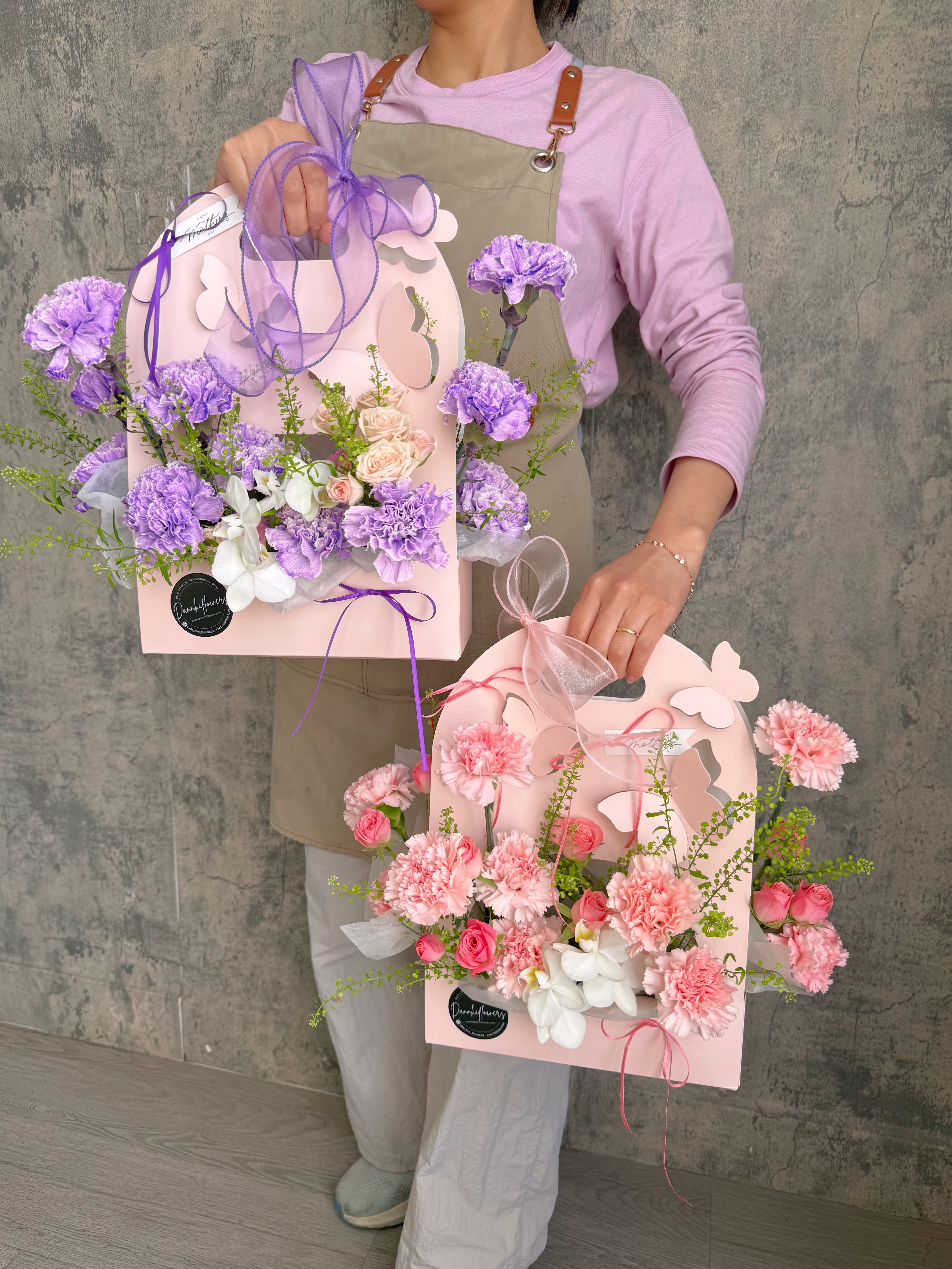 Butterfly kisses. - Delicate blooms in soft pastel tones, nestled in a charming butterfly pink bag, a sweet and graceful gesture to celebrate Mom’s love, beauty, and gentle spirit.