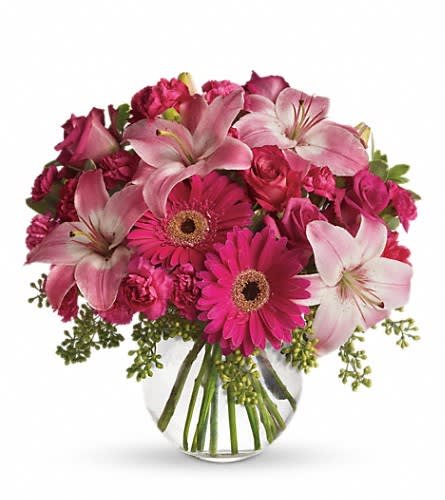 Pink lilies and gerbera daisies in a clear glass vase