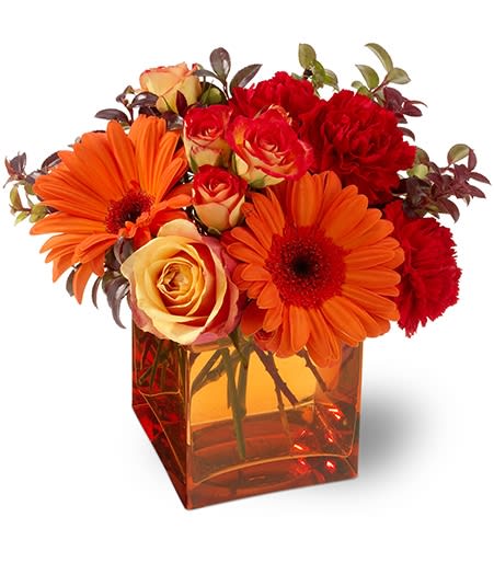 Sunrise Sunset   - Everyone loves a glowing sunrise or sunset... it's the most beautiful part of the day! We've captured those fiery colors in this vibrant flower arrangement, featuring orange and red blooms nestled in a glass cube vase. Send this fun bouquet, and add a bright spot to any home or office. Approximately 8" (W) x 9" (H)