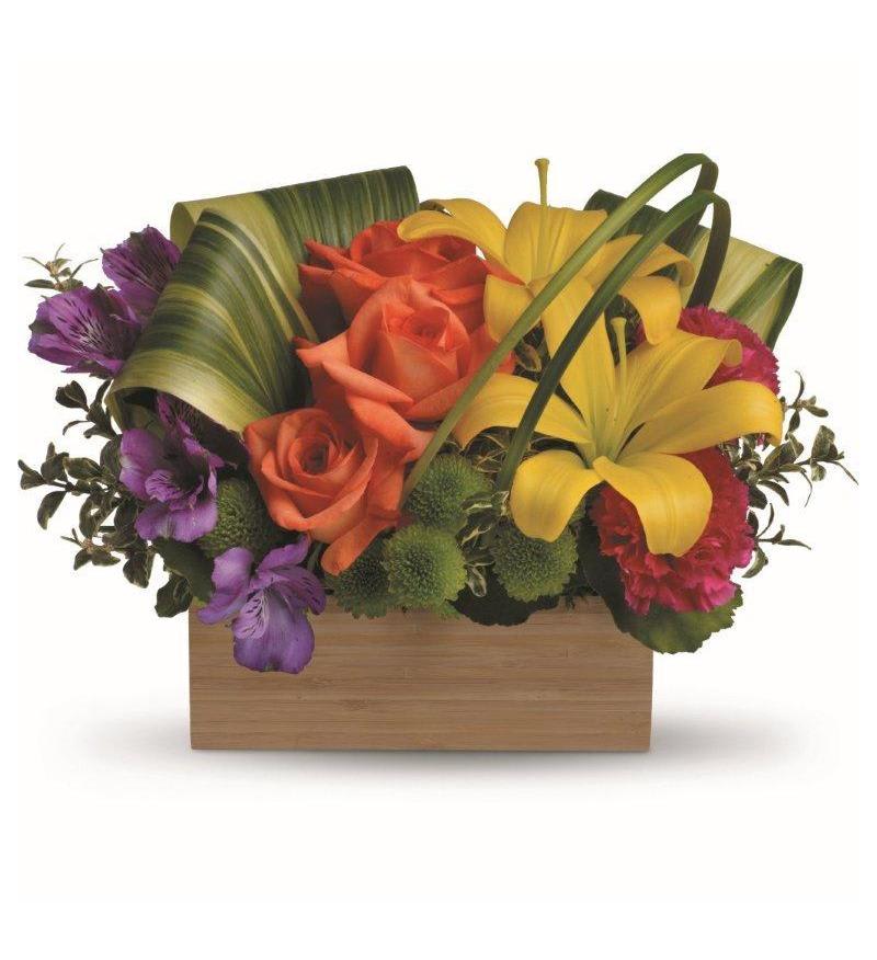 Teleflora's Shades Of Brilliance Bouquet   - Send her a rainbow! Golden lilies, radiant roses and regal alstroemeria burst brilliantly from a contemporary bamboo box. What a chic, stunning way to brighten her day! Approx. 14 W x 10 H 