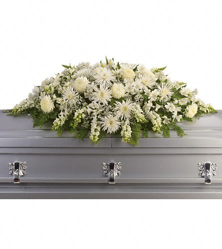 White floral casket spray arranged on a gray casket