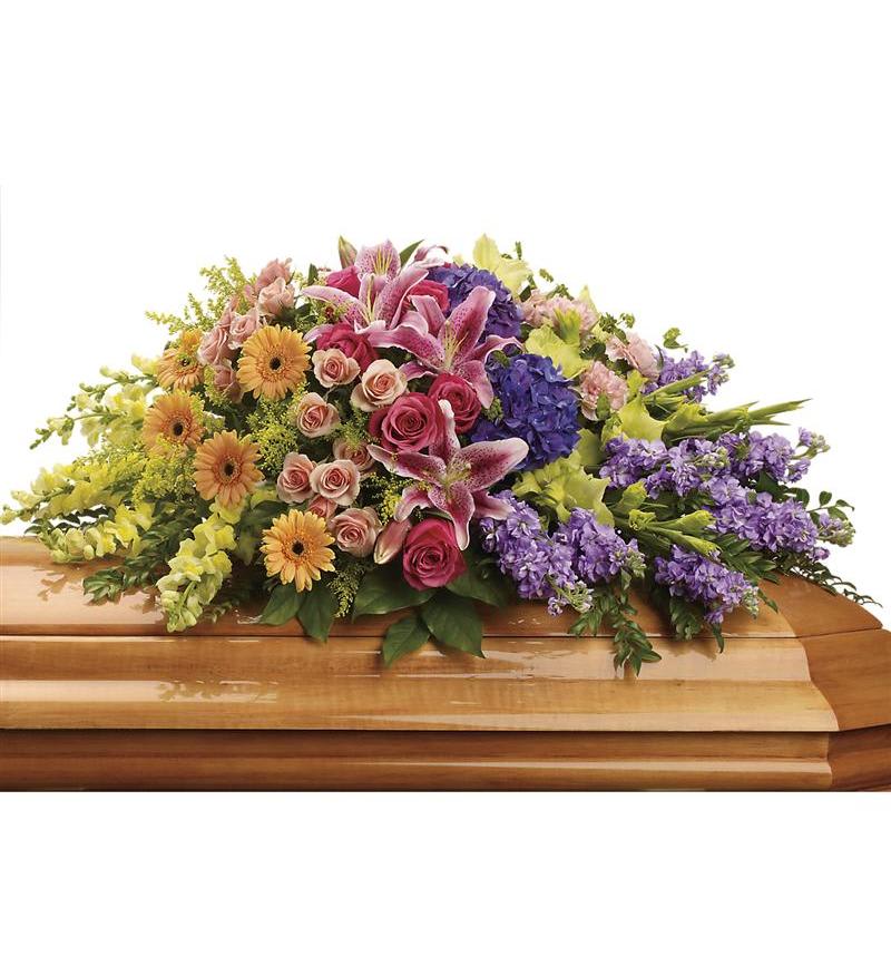 Colorful floral spray arranged on a wooden casket