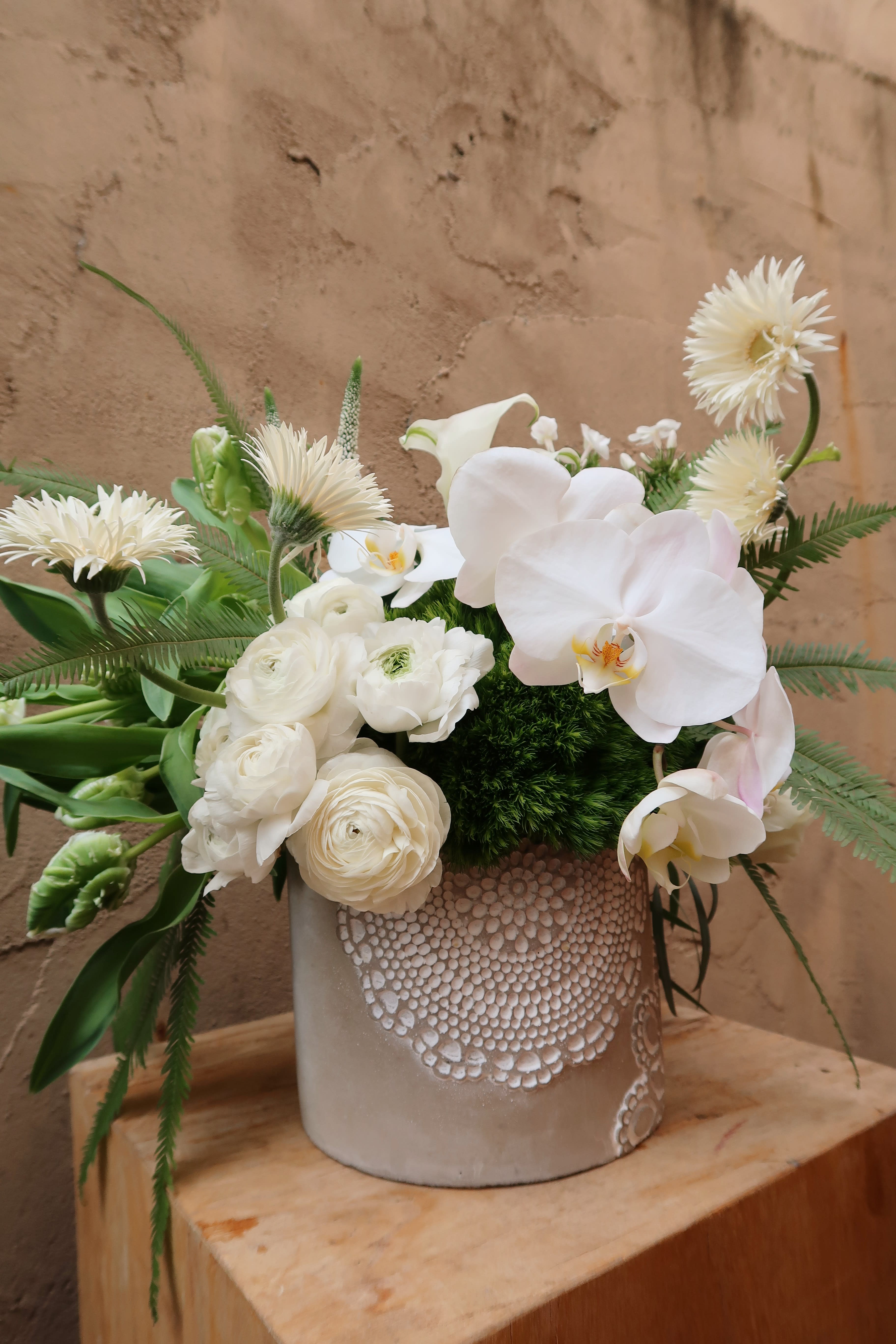 Timeless - Timeless, features an elegant ceramic vase with a lace trimming design filled with stunning white and green blooms. 