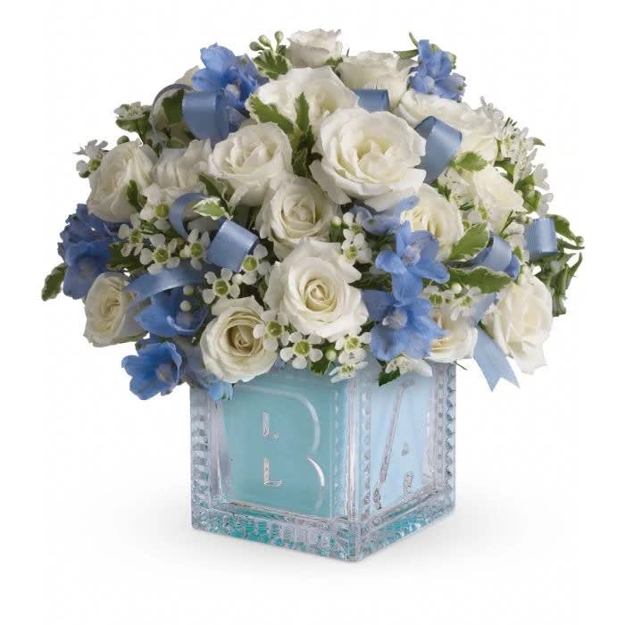 White and blue rose arrangement in a glass block vase