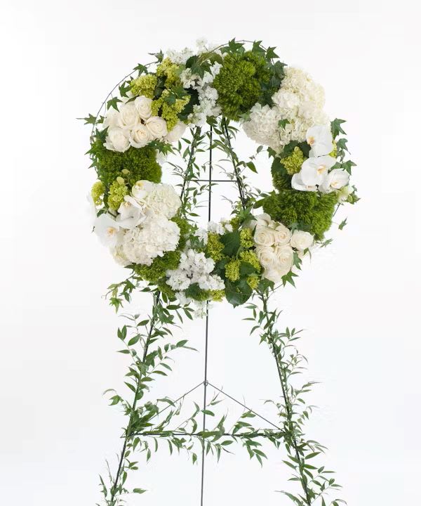 White and green floral wreath on a standing easel