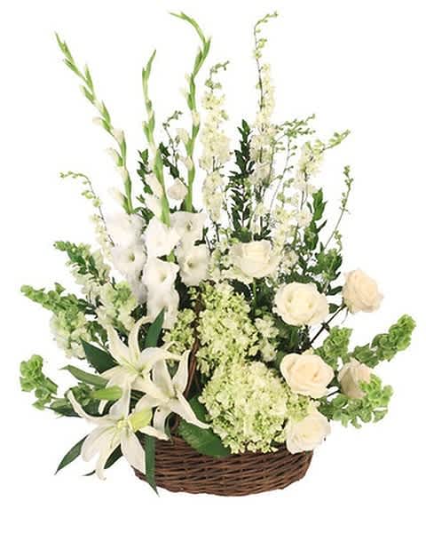 White floral arrangement in a wicker basket with lilies and roses