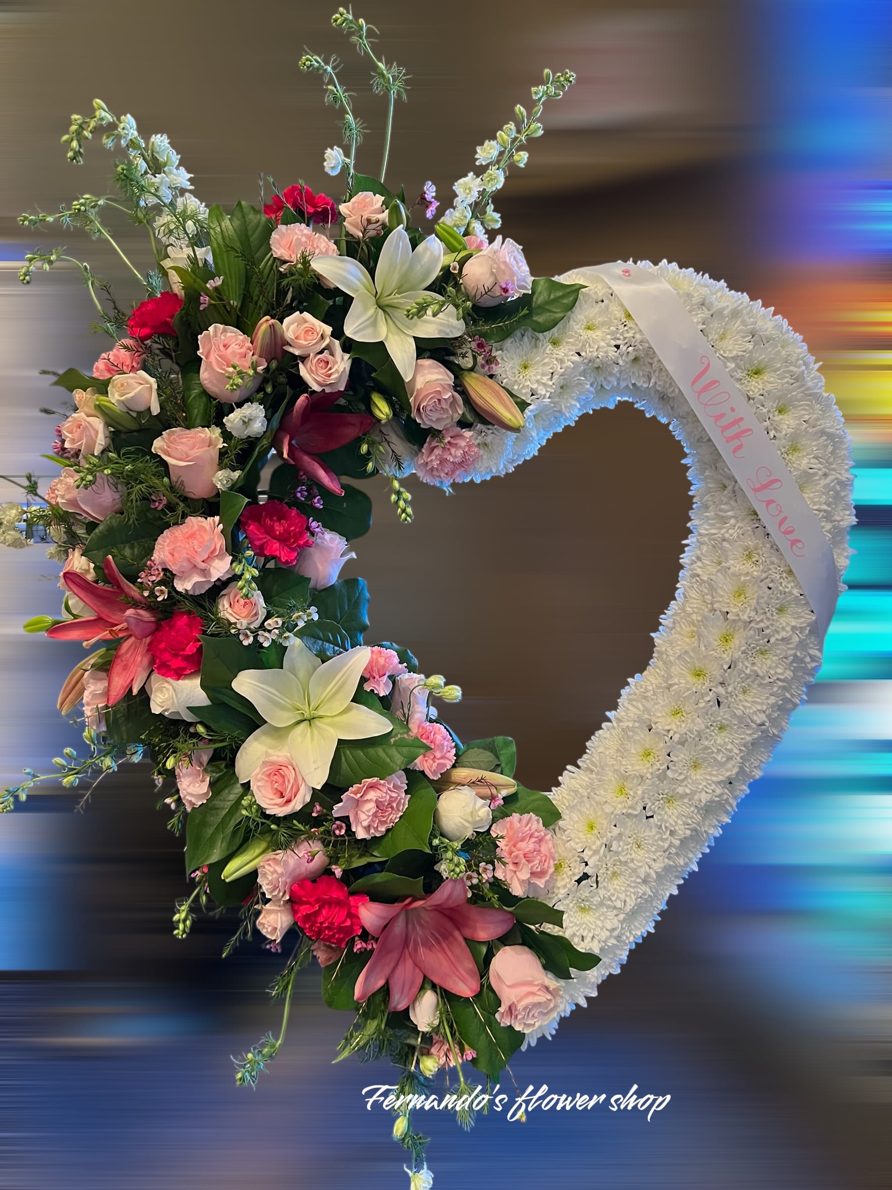 Open heart wreath of white flowers with pink roses, lilies, and carnations and a ‘With Love’ ribbon