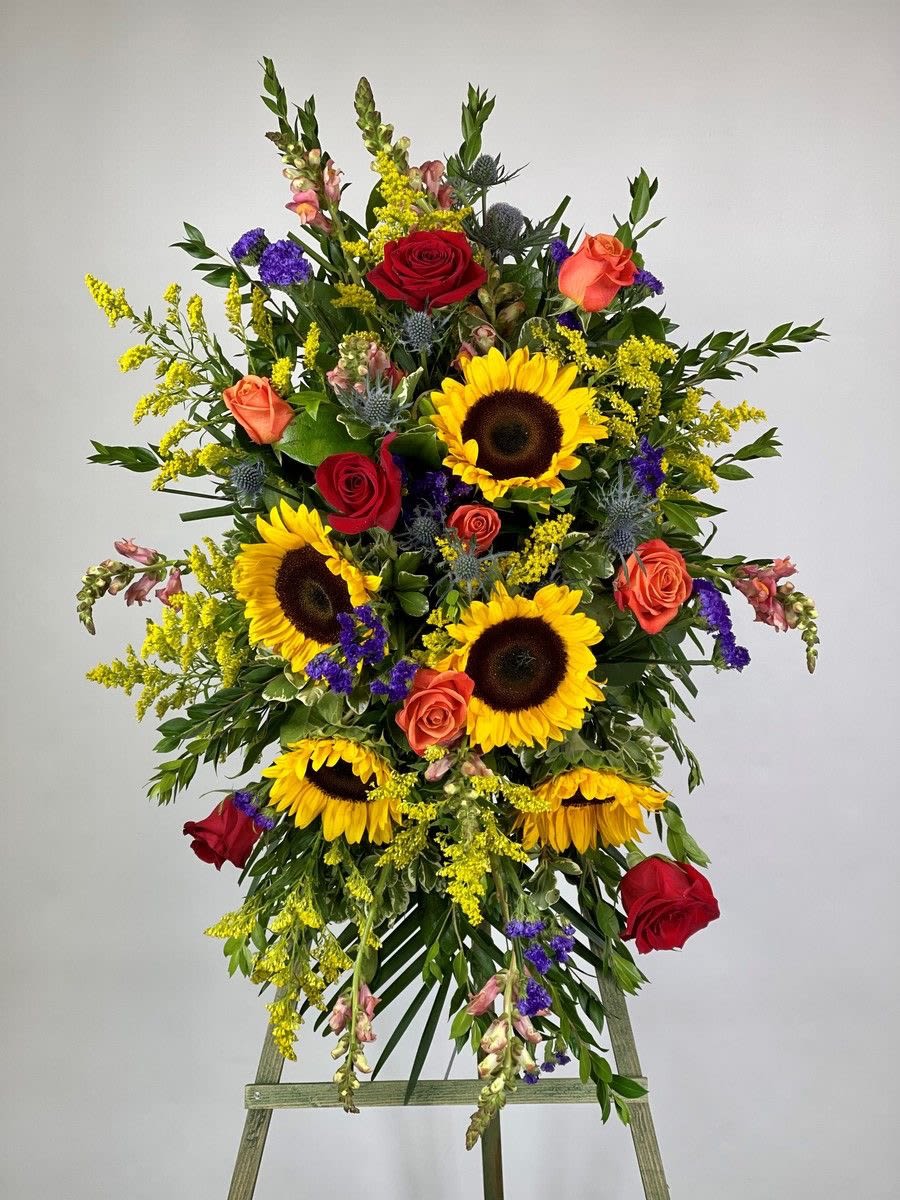 Tall standing spray of sunflowers and roses on a wooden easel