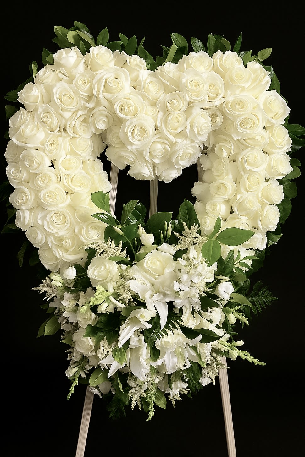 Heart-shaped standing wreath of white roses with cascading white lilies and blooms
