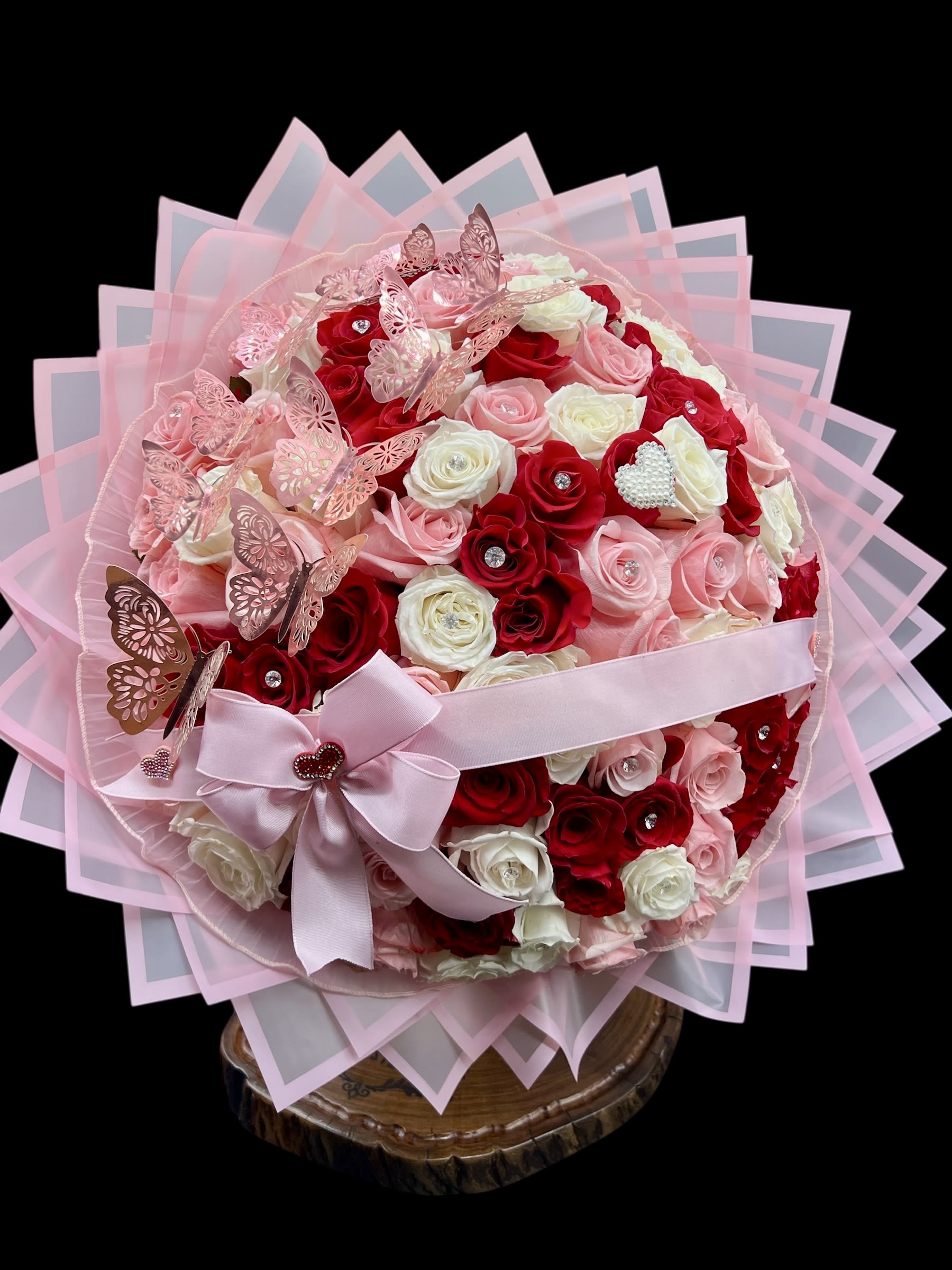Pink and red rose bouquet with butterflies and a ribbon bow