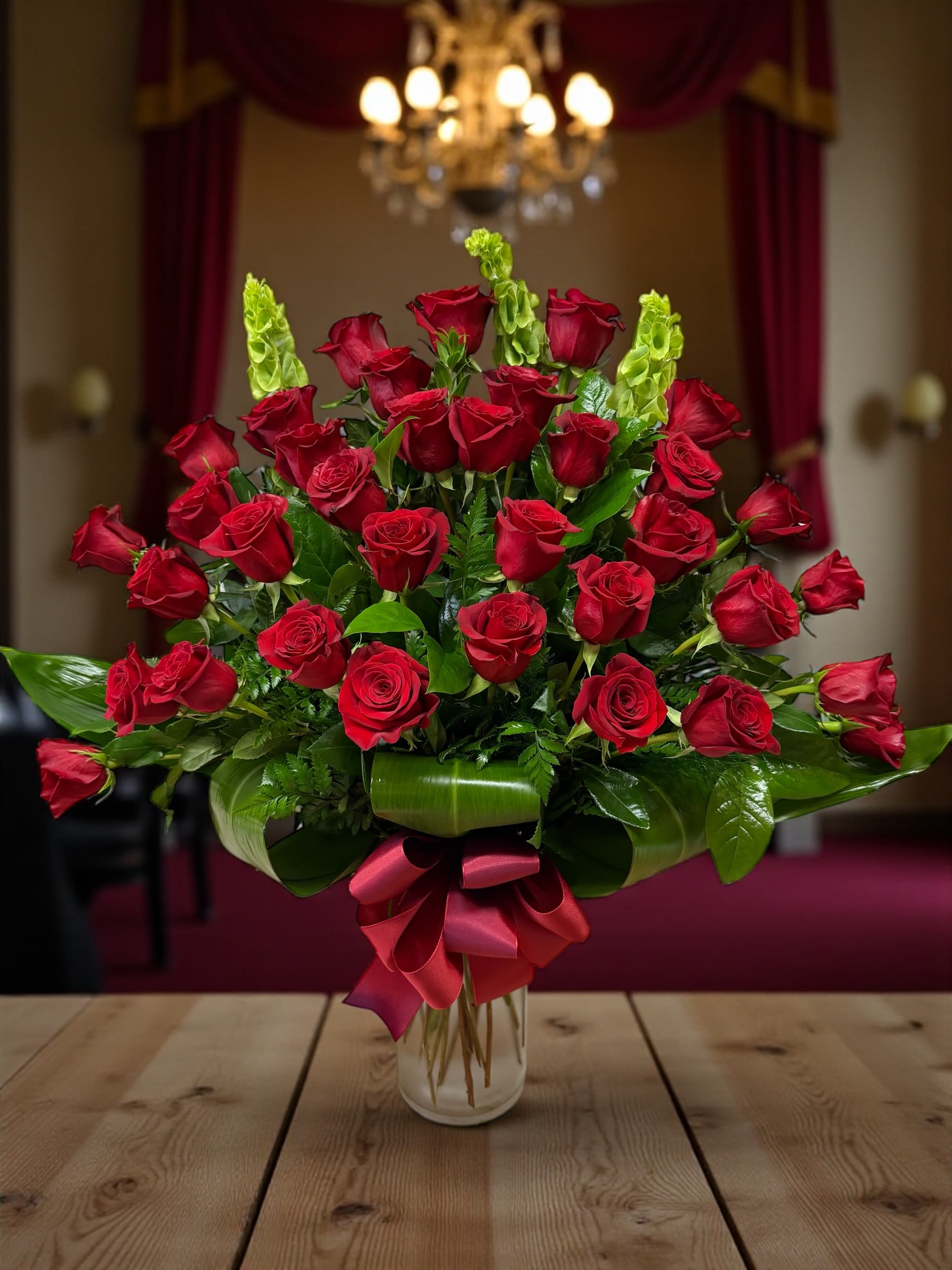 Bouquet of red roses with green accents in a glass vase