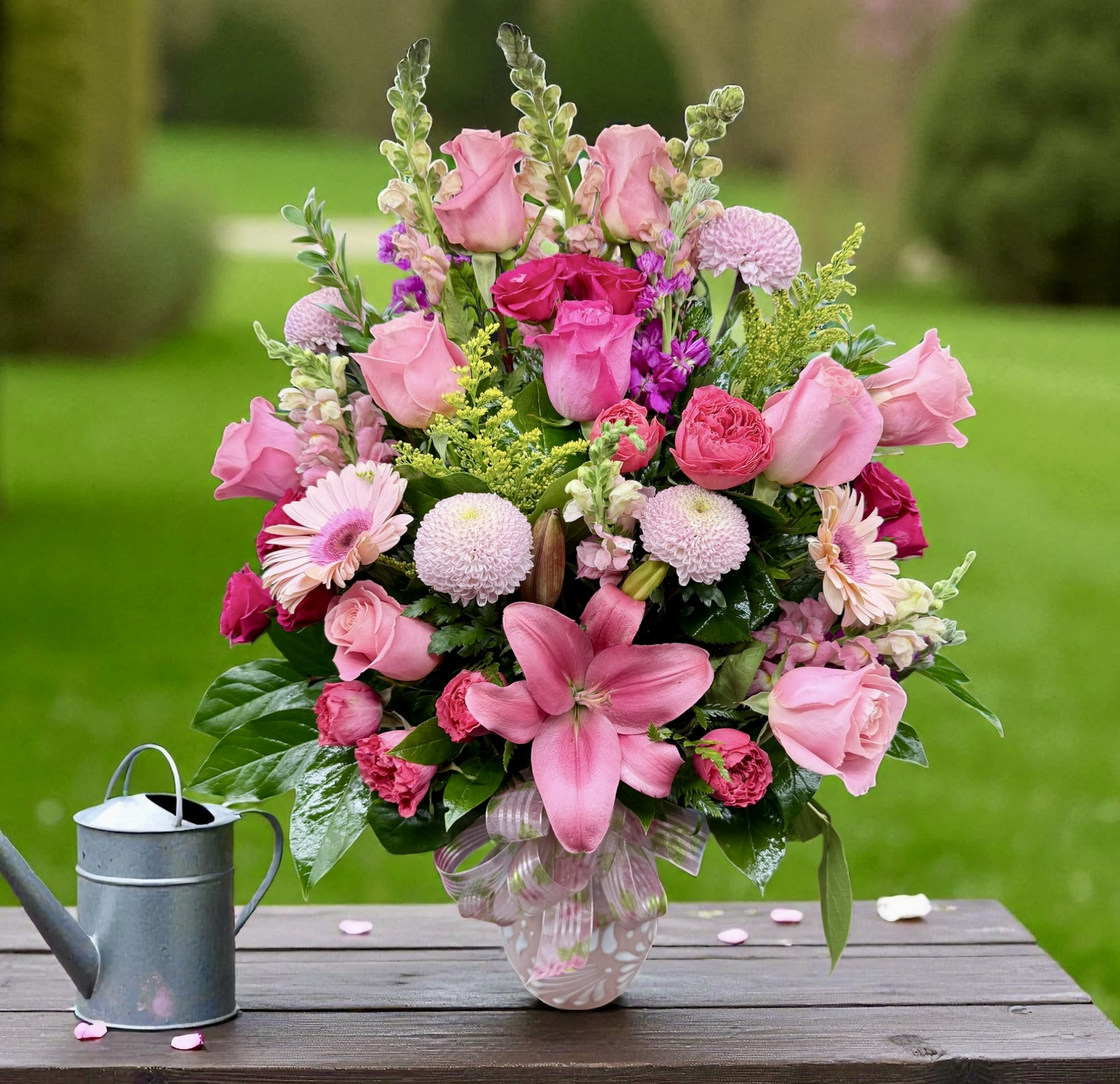 Pink mixed flower arrangement in a glass vase on a table