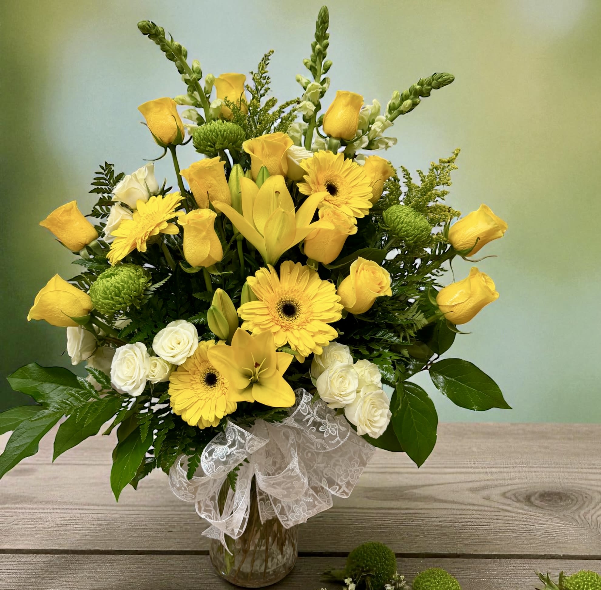 Best Friends - Bright and elegant arrangement designed with yellow roses, lilies, gerberas, and white spray roses, complemented by fresh greenery and soft textures. A vibrant piece full of joy, perfect to lift spirits, celebrate special moments, or brighten any space.