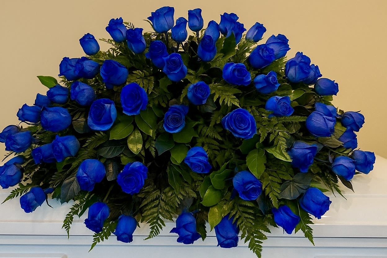 Large spray of vivid blue roses arranged in a low mound on a white surface