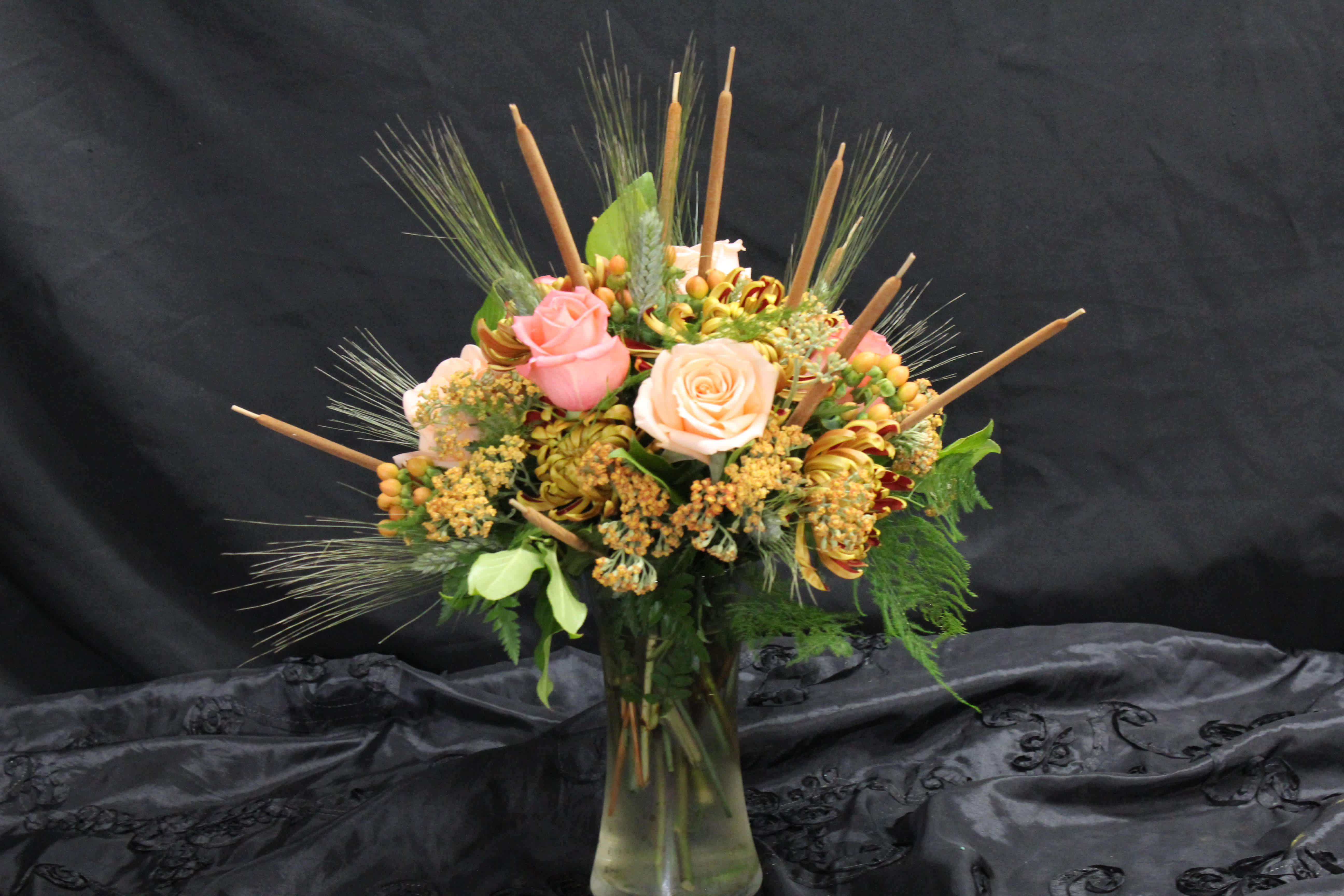 Blush and Peach Fall Vase Arrangement - Blush and peach roses are grouped with wheat, cattails, peach hypericum berries, bicolor mums, and a peach accent flower to create a subtle, but beautiful fall arrangement.