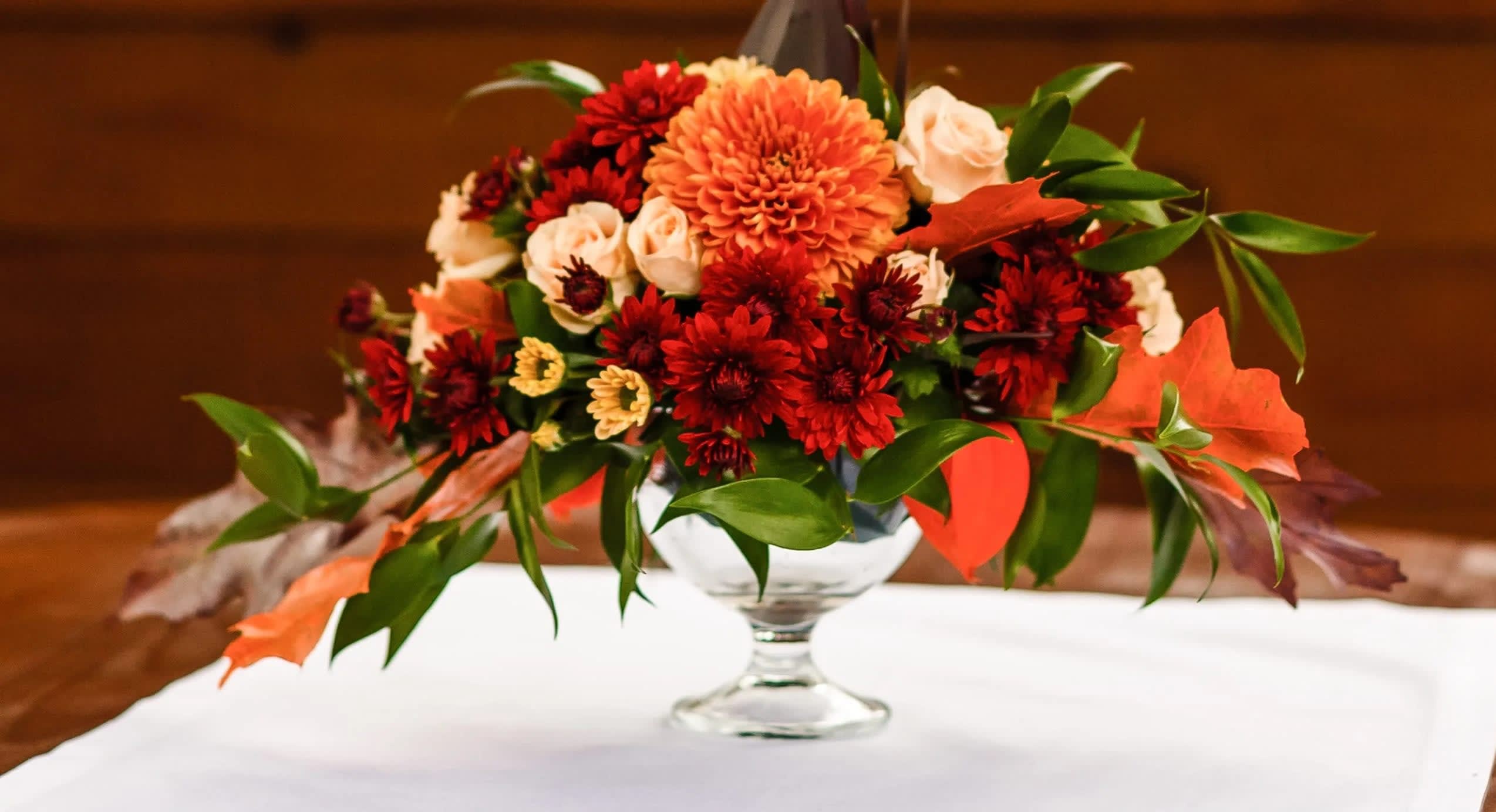 Autumn Beauty - A beautiful assortment of fall garden flowers designed in a glass pedestal vase.