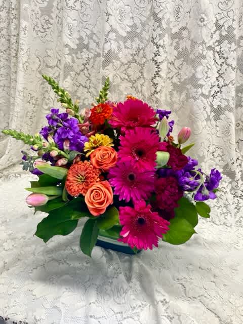  Runway Ready Bouquet  -  Starting with soft peach roses, its colors flow seamlessly to orange spray roses and carnations, then hot pink gerbera daisies and into purple button poms and plum carnations.  It makes a stunning birthday, anniversary, or get well gift.