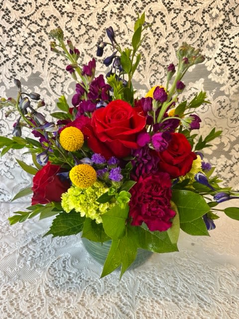 Bejeweled - A glass bowl with rich, jewel toned flowers. Ruby, sapphire, emerald, citrine, and amethyst are the colors you will find in this stunning arrangement.