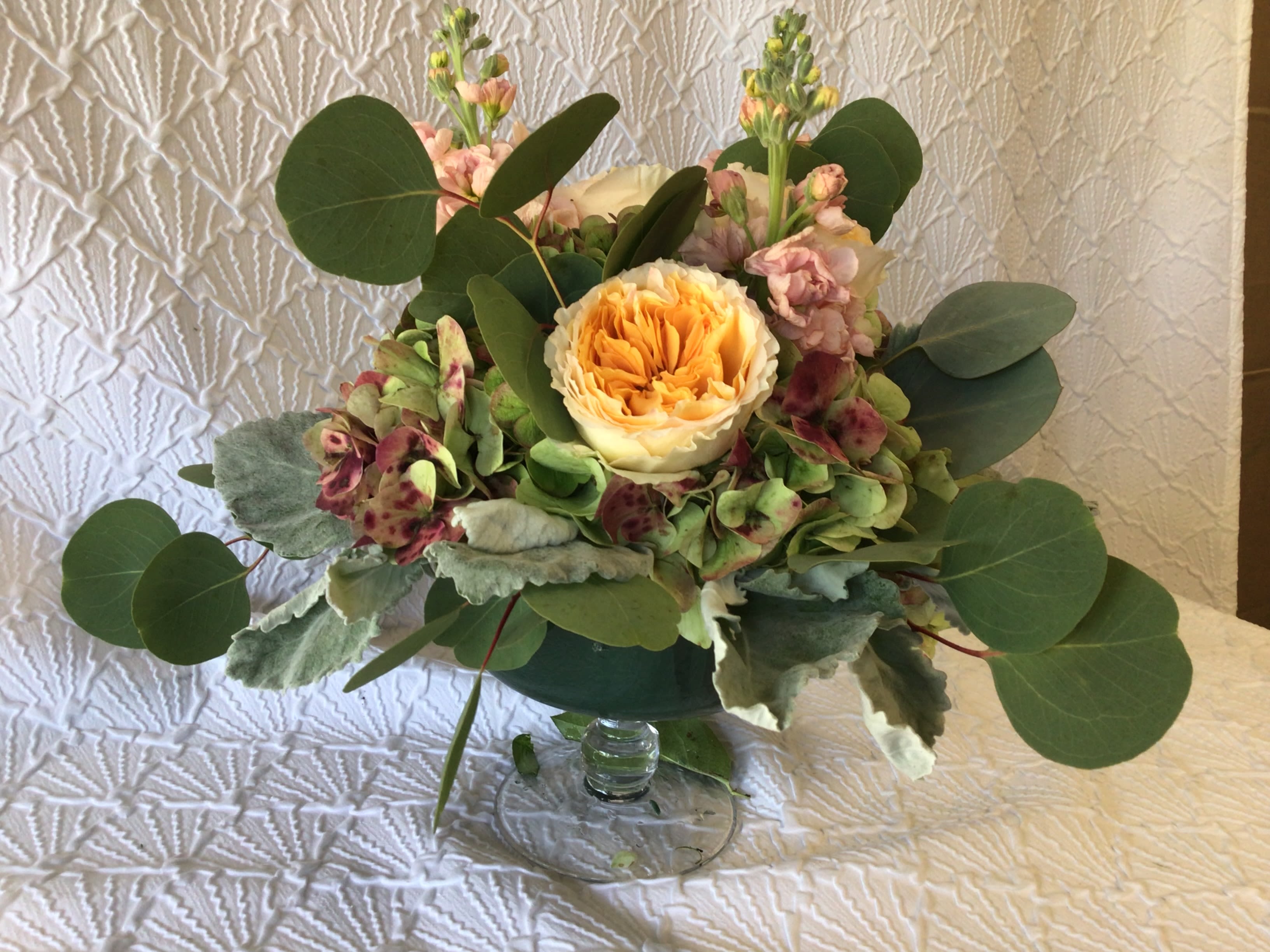 Bouquet of peach and pink flowers in a clear glass vase