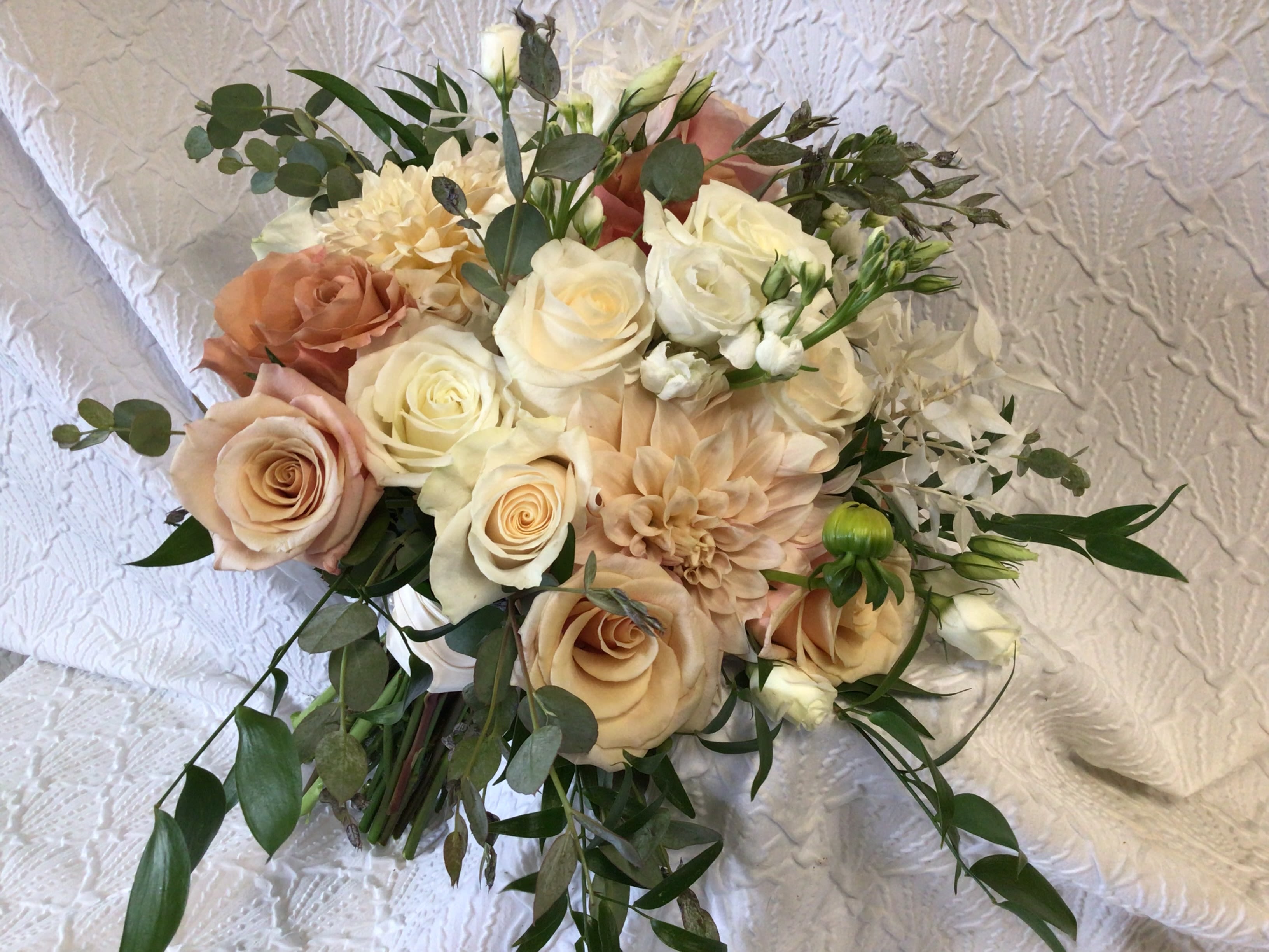 Bouquet of cream and peach roses with greenery