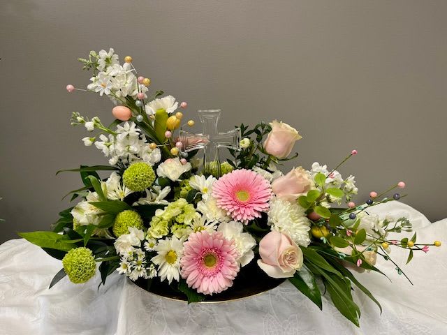 Pastel floral arrangement with a clear cross centerpiece